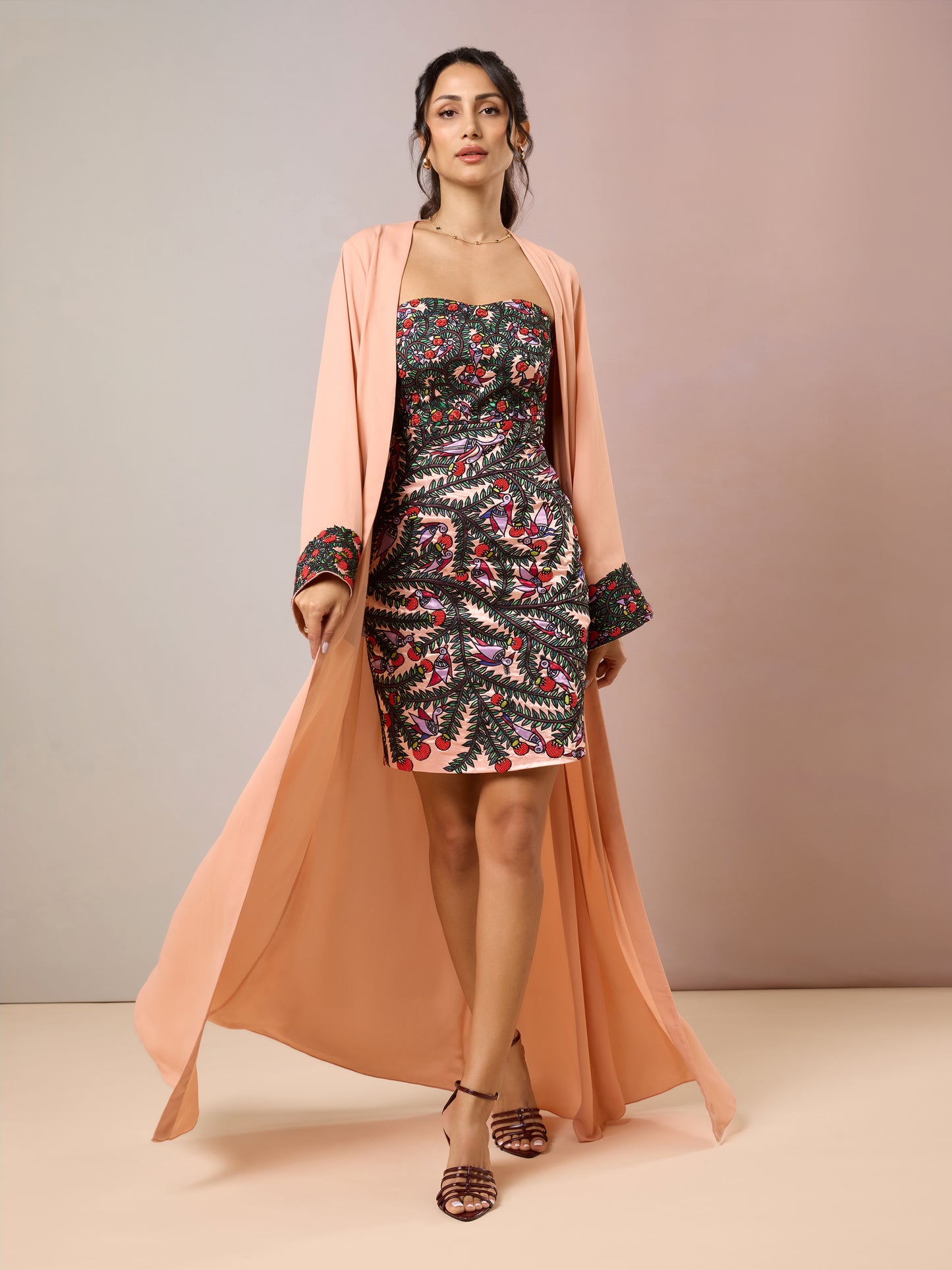 Model in floral strapless mini dress with peach cape