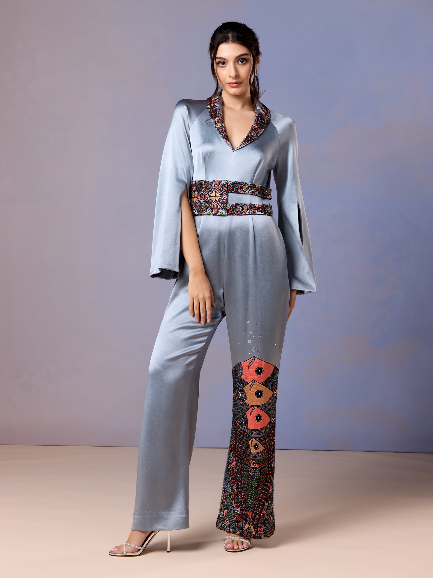 Front view of glacier blue silk jumpsuit with floral embroidery on leg
