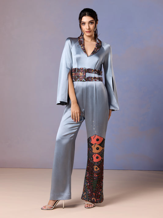 Front view of glacier blue silk jumpsuit with floral embroidery on leg