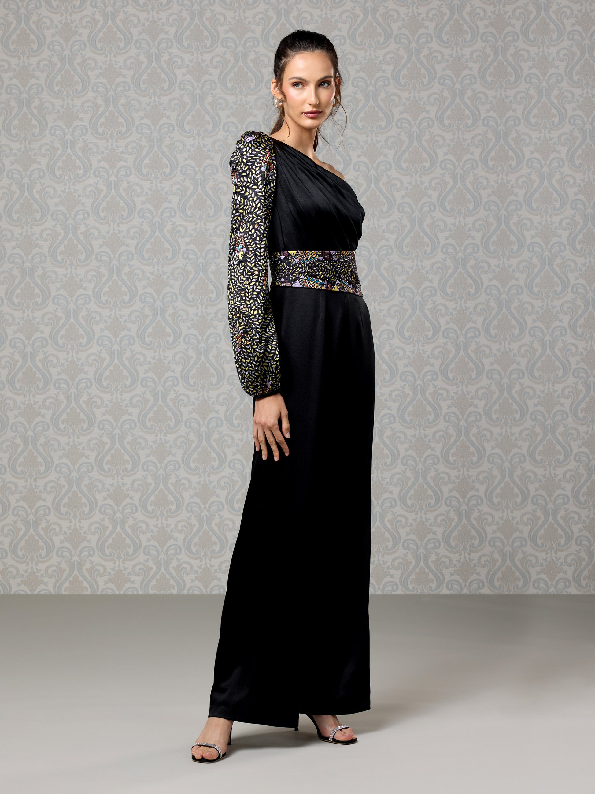 Full-length black satin jumpsuit with asymmetrical design and sequin waist detail