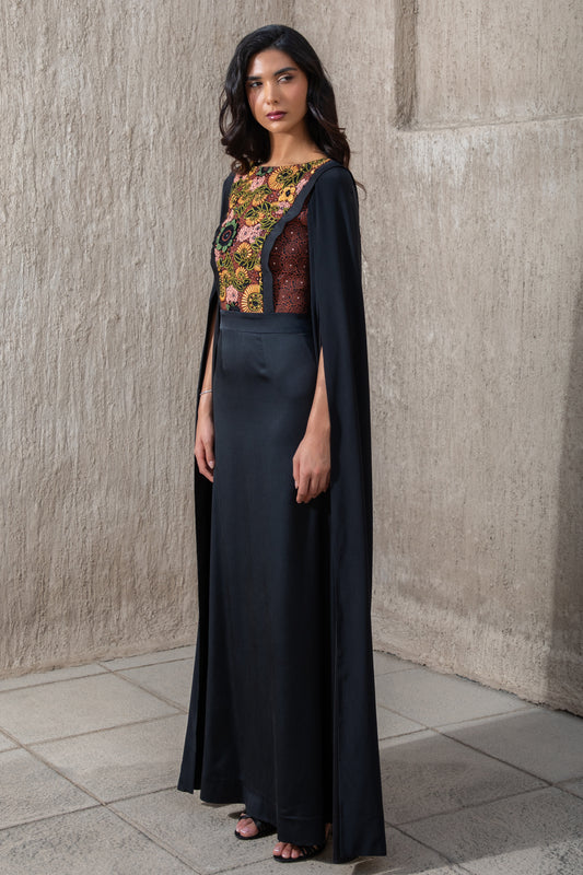 Side view of black cape sleeve gown with vibrant embroidered bodice