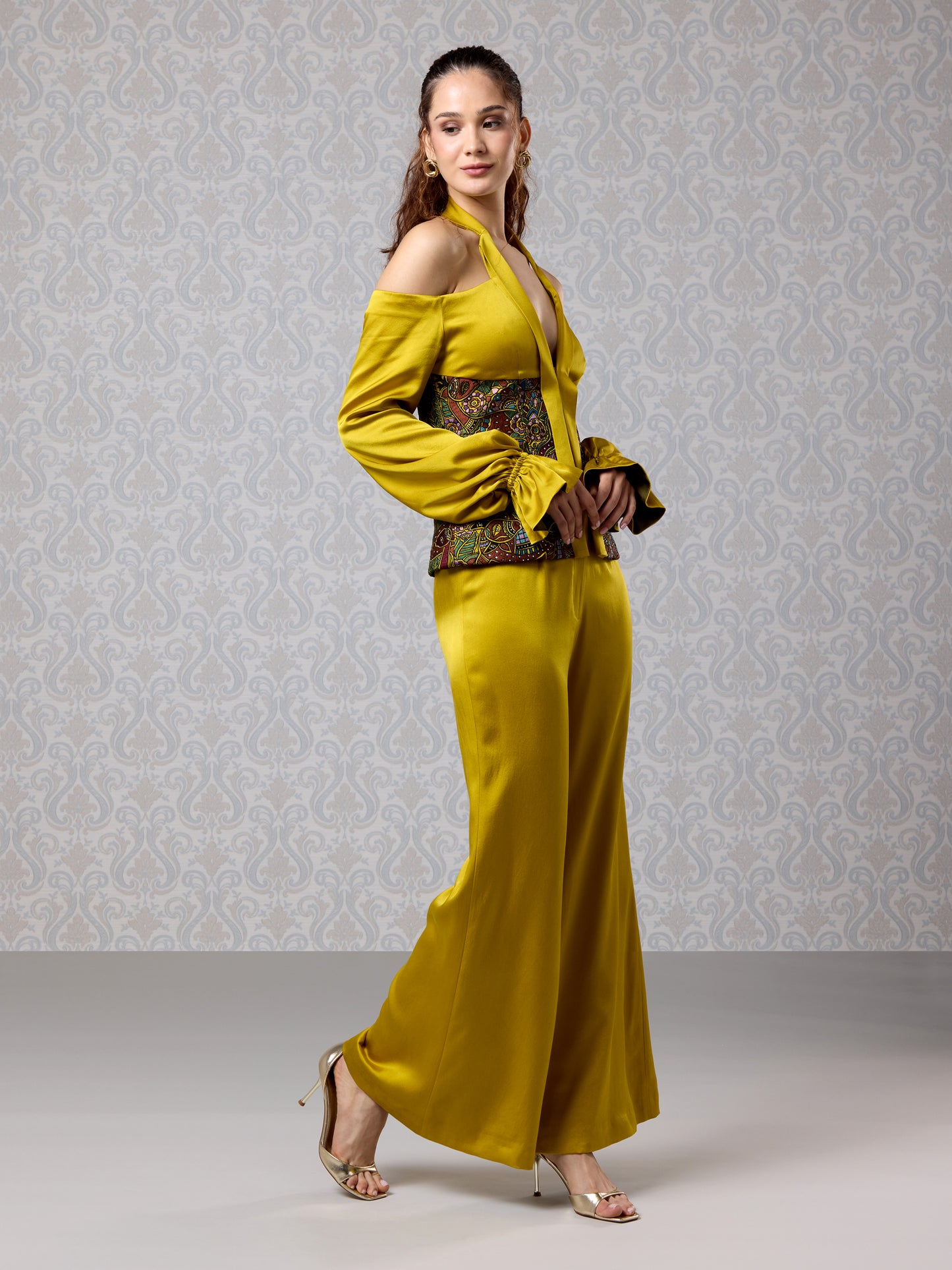 Model in gold satin co-ord set featuring printed corset and wide-leg pants