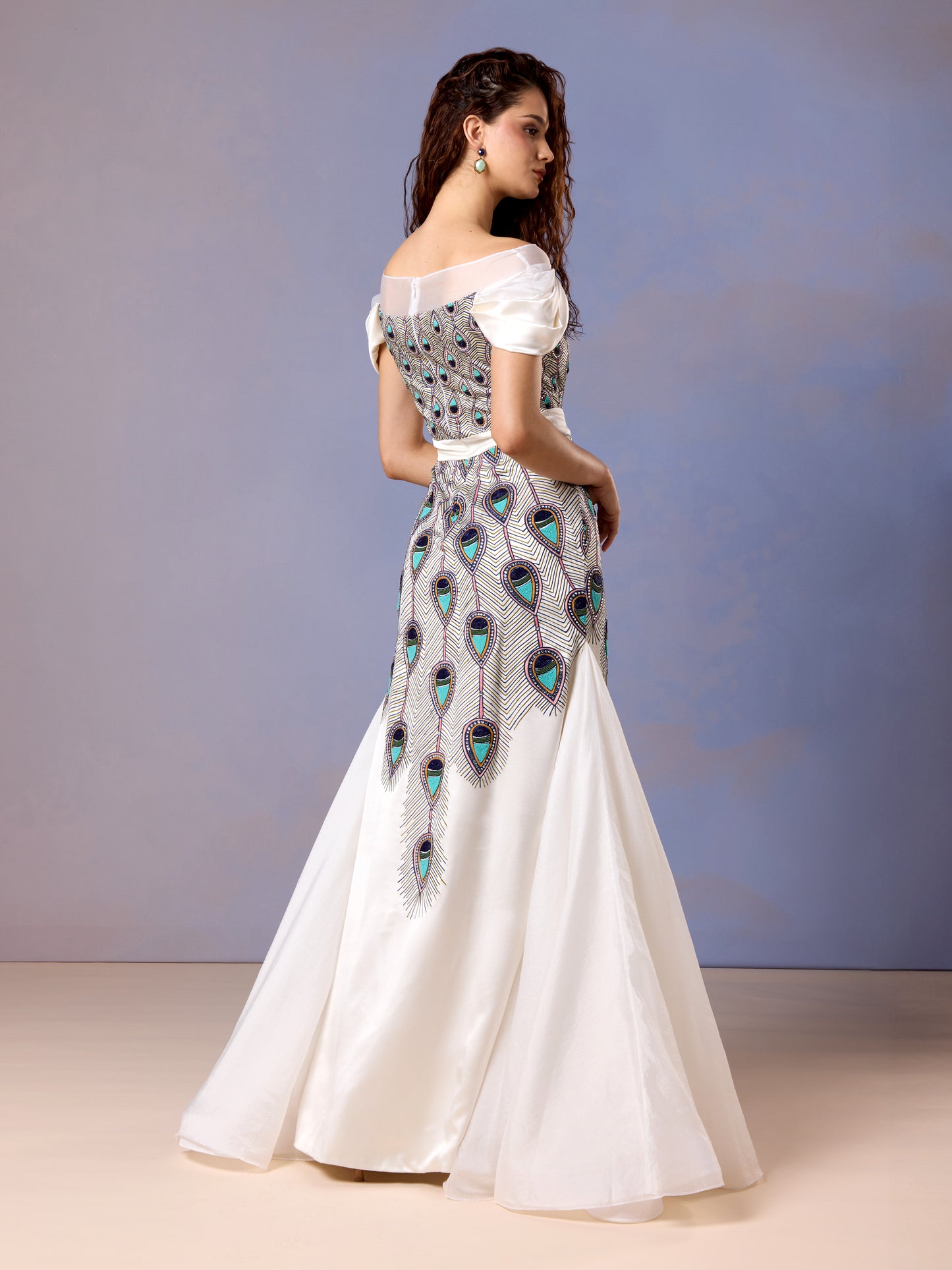 Side view of white silk satin gown with elegant flare and detailed waist embroidery