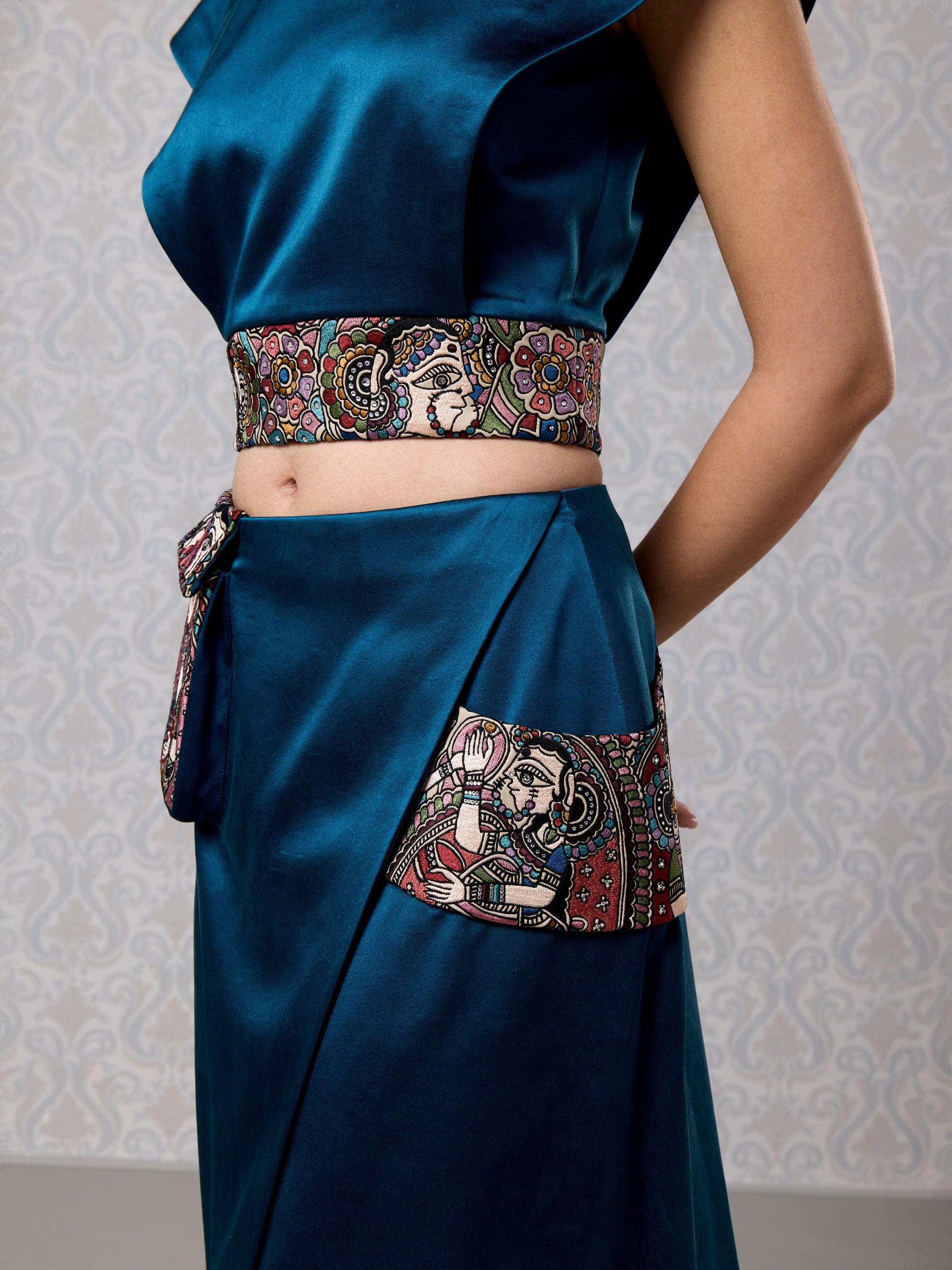 Close-up of blue satin outfit with detailed vegan leather waist panel