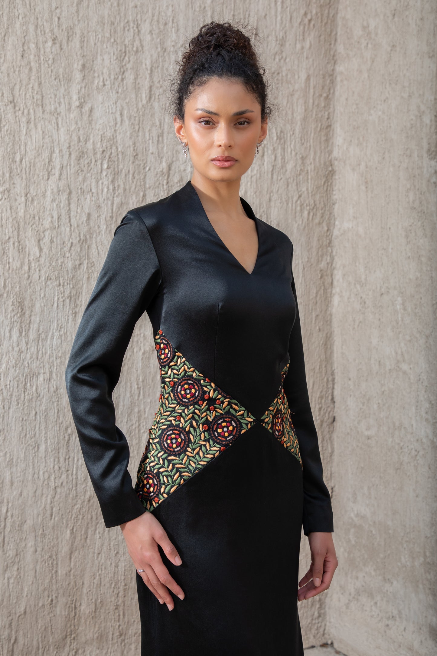 Detailed close-up of waist embroidery on black evening gown