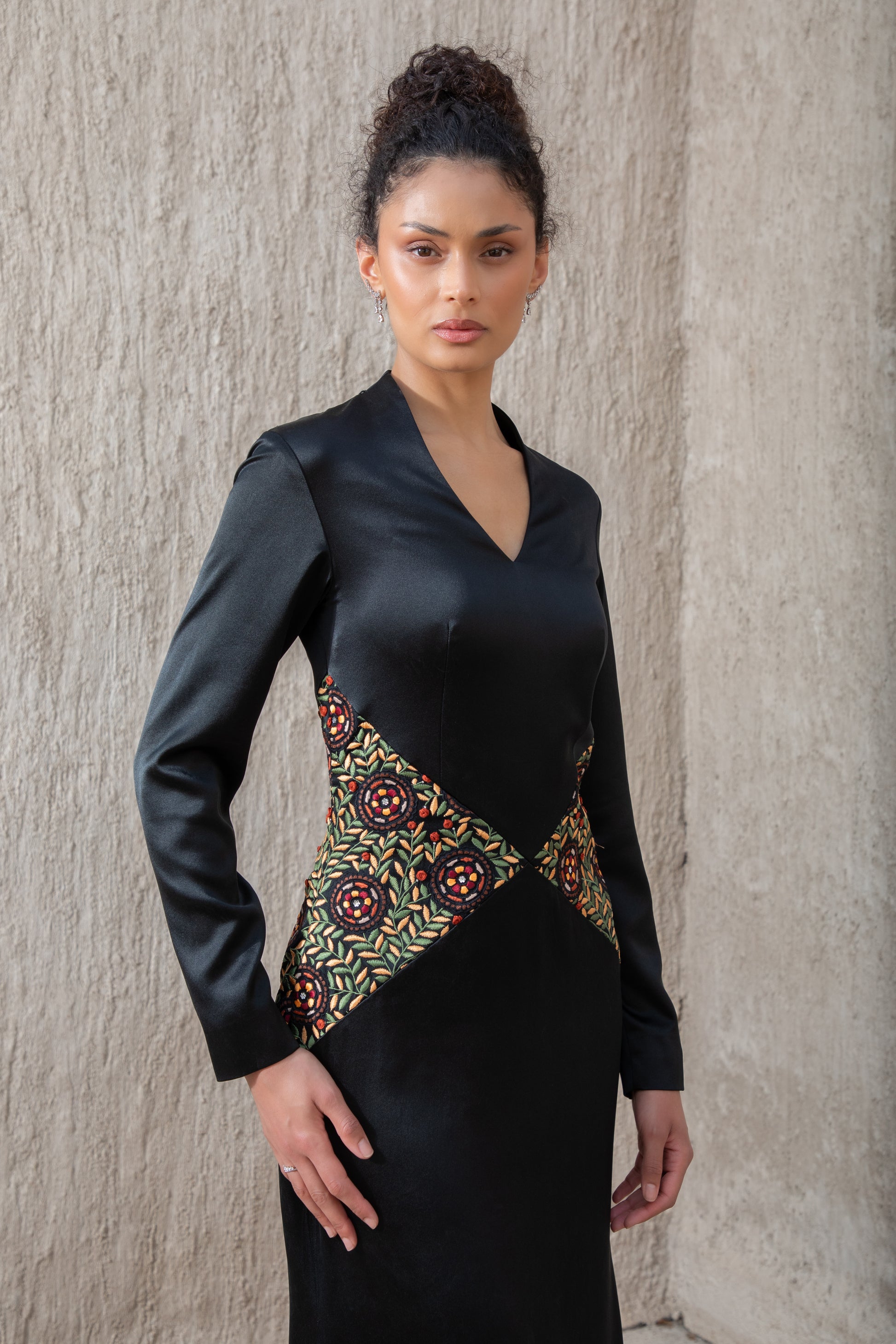 Detailed close-up of waist embroidery on black evening gown