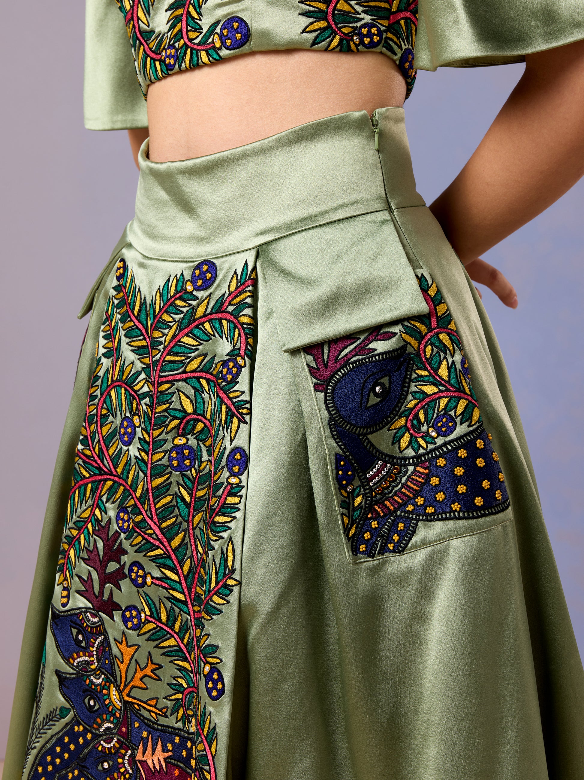 Zoomed-in embroidery detail on pocket of sage green flared skirt