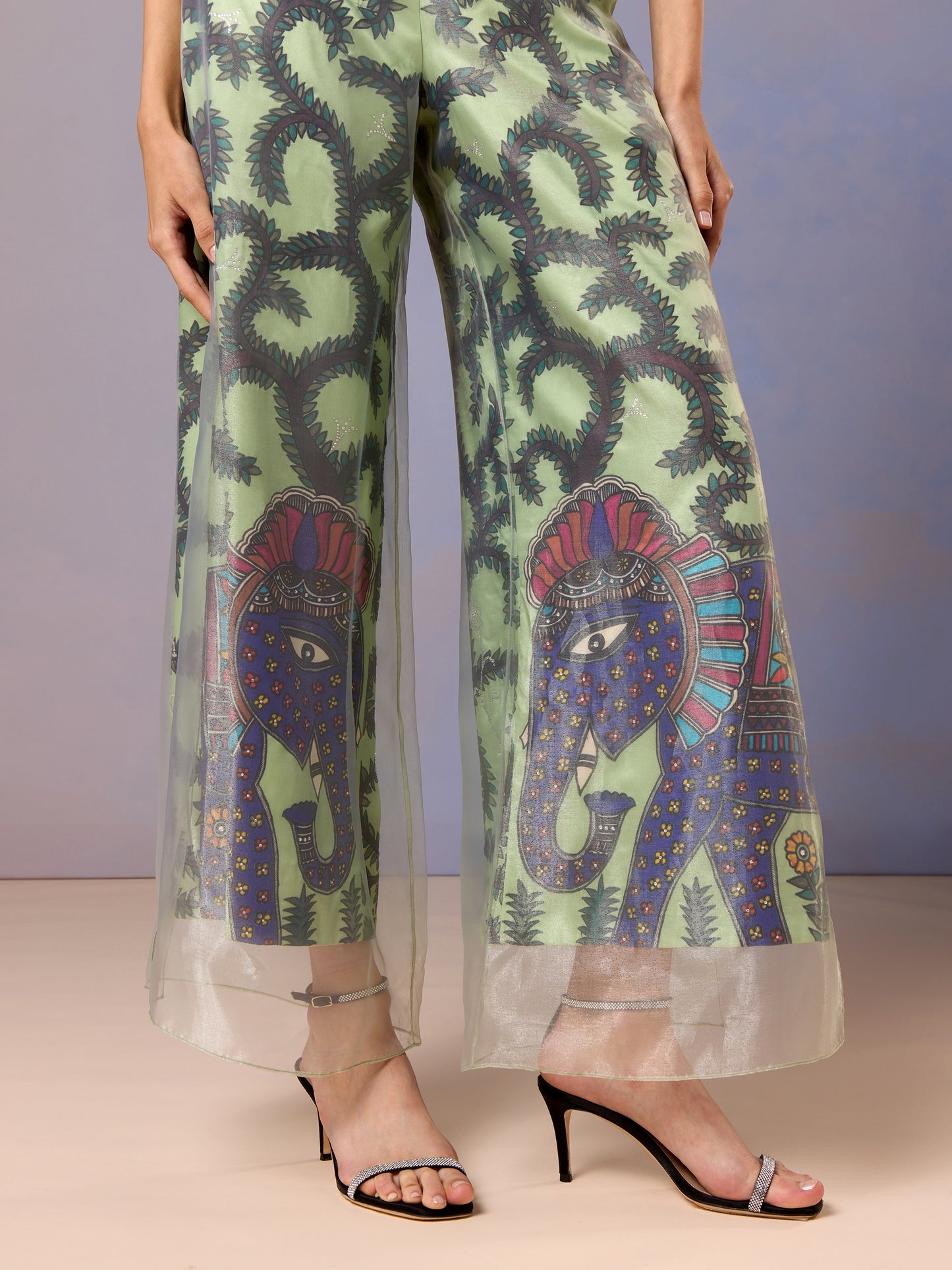 Detailed embroidery and floral patterns on sheer Sage green trousers