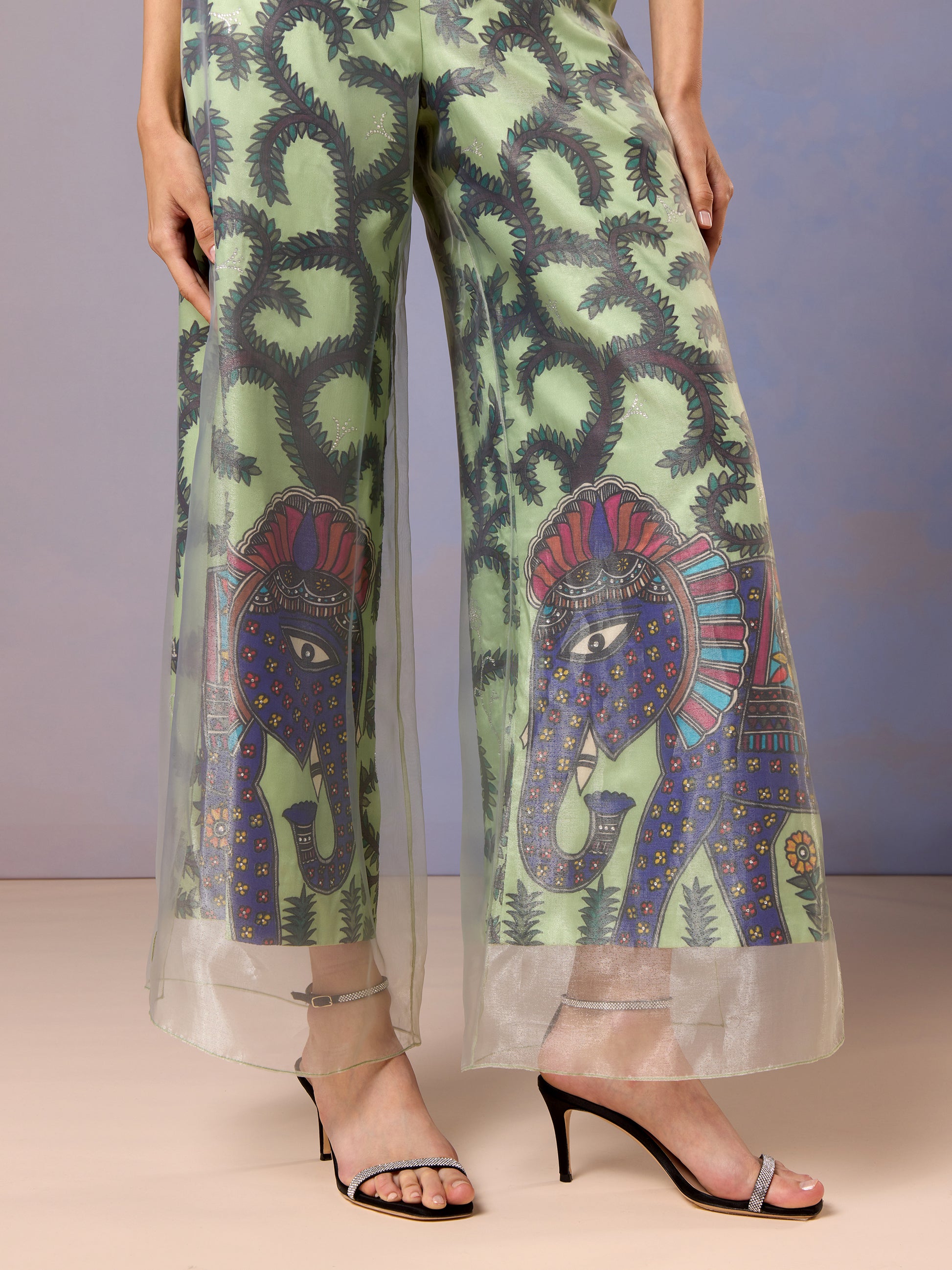 Detailed embroidery and floral patterns on sheer Sage green trousers