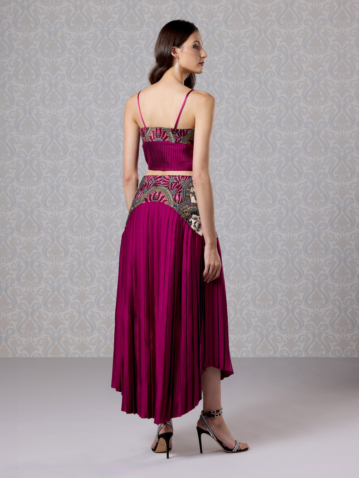 Side view of cranberry co-ord set with high-low skirt and intricate vegan leather work