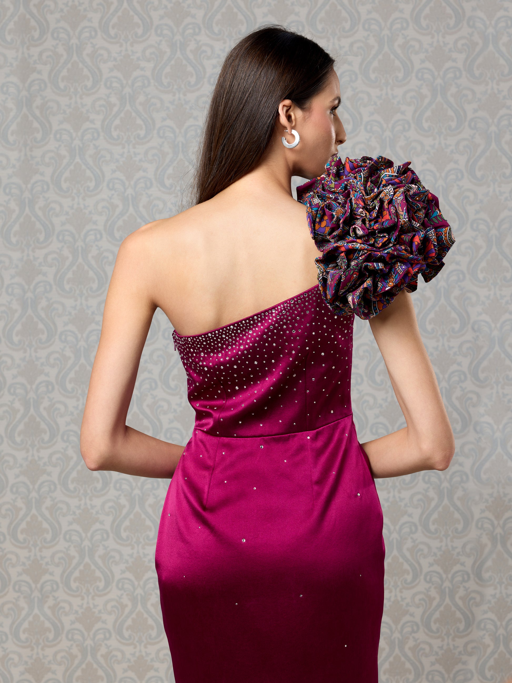 Close-up of georgette ruffle detailing on cranberry one-shoulder satin dress