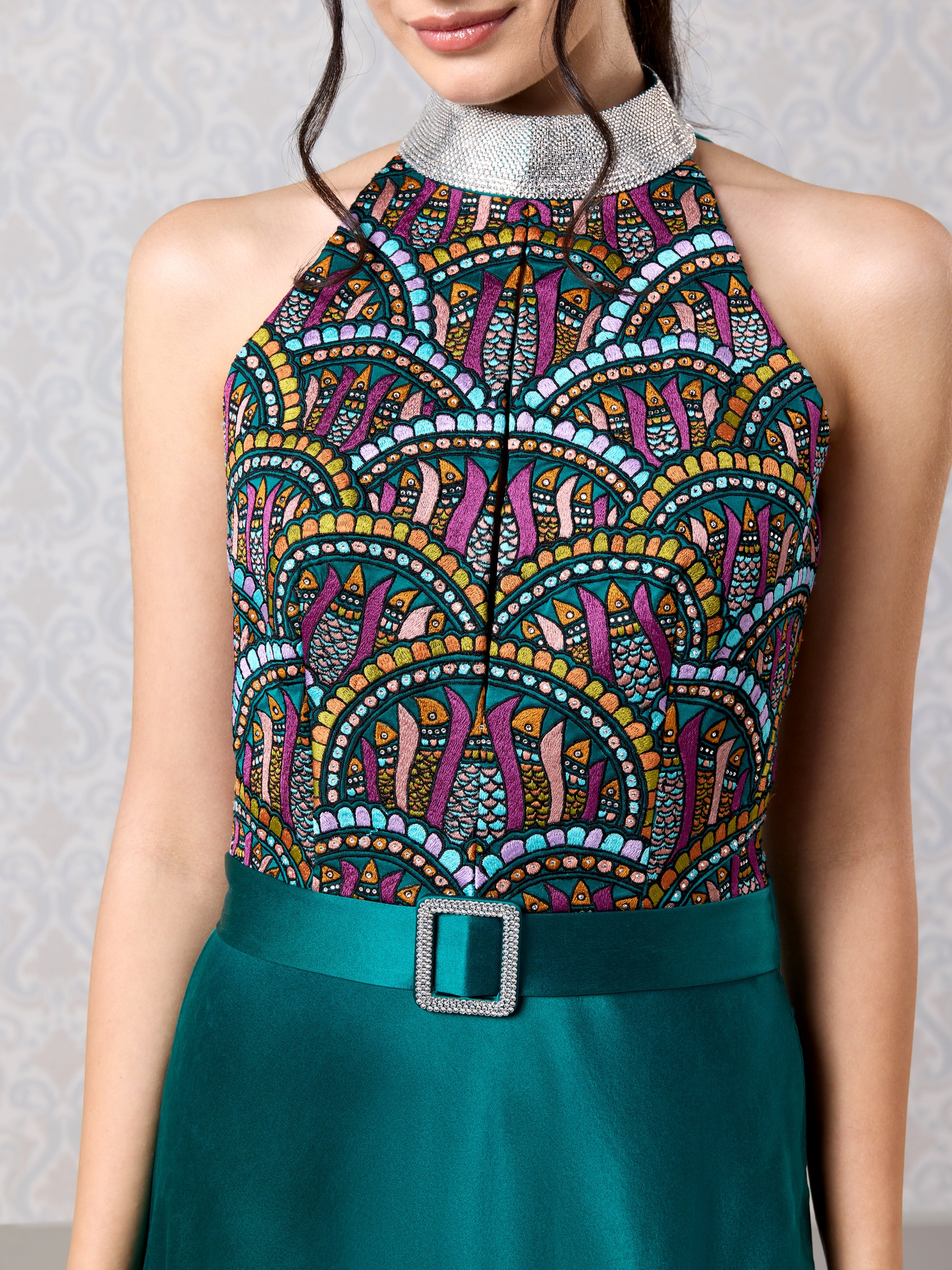 Close-up of embroidered bodice on emerald silk satin asymmetrical dress