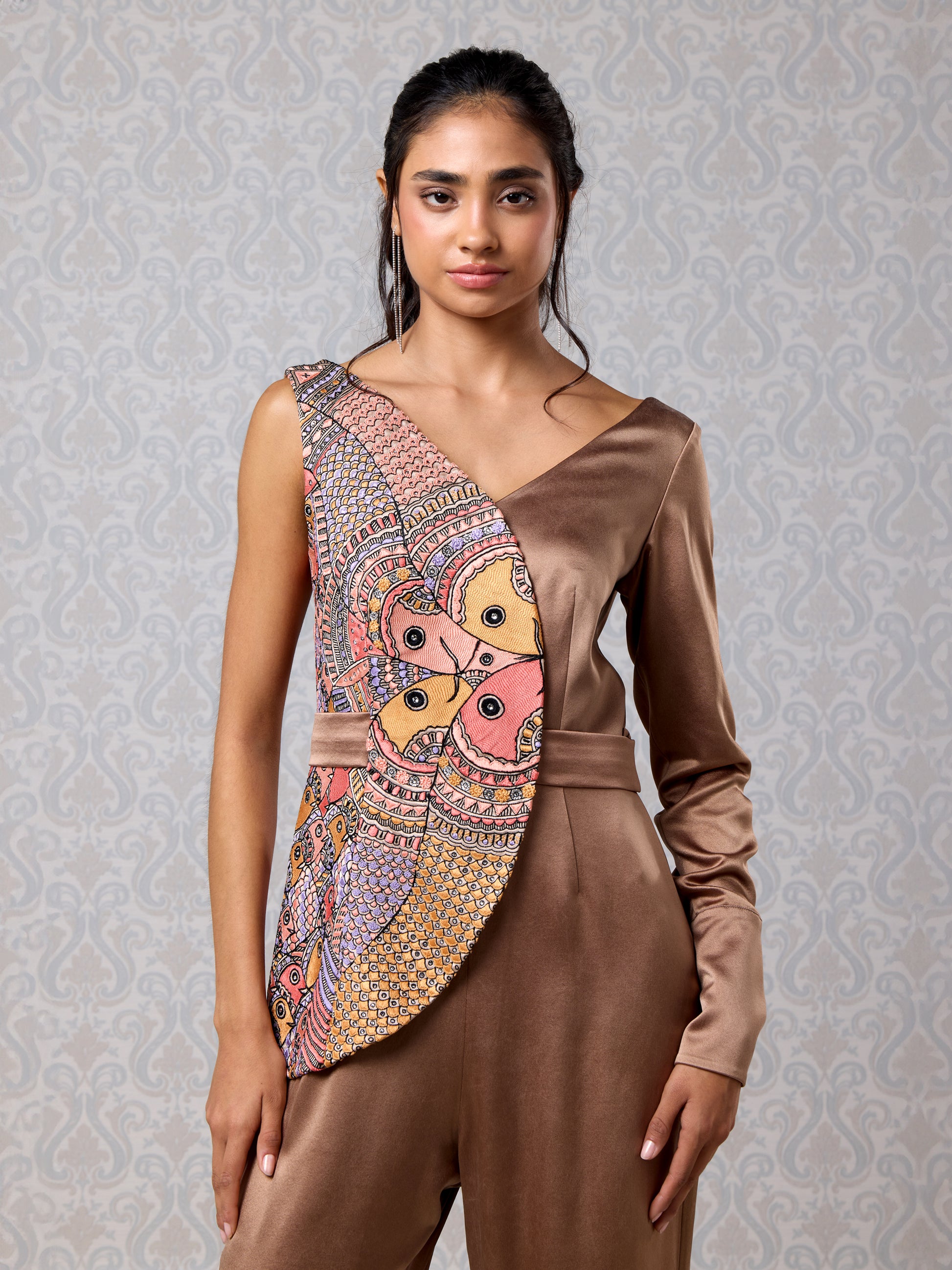 Women front-facing in asymmetrical vanilla and brown silk jumpsuit with long sleeve