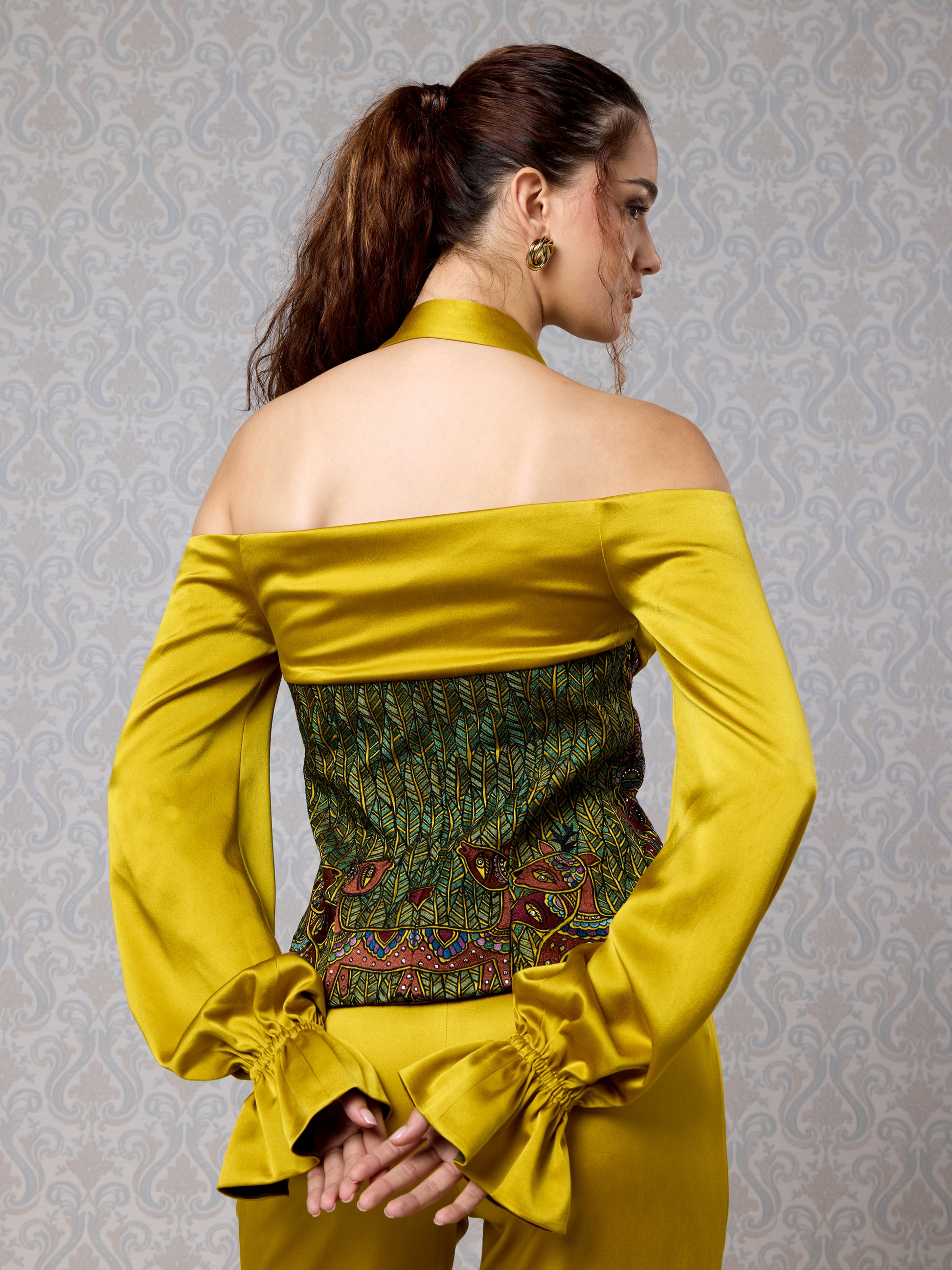 Back view of off-shoulder silk satin top and high-waist trousers