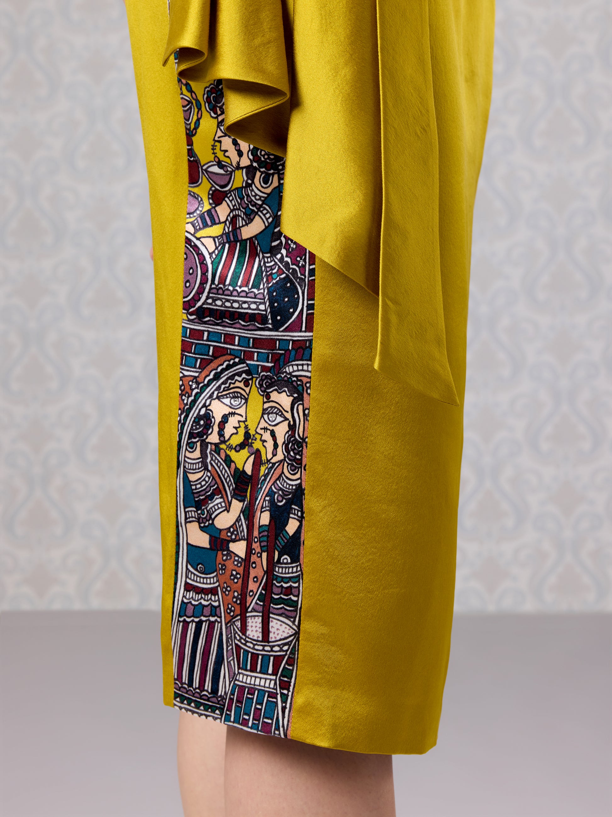 Close-up of draped satin top and embroidered on skirt