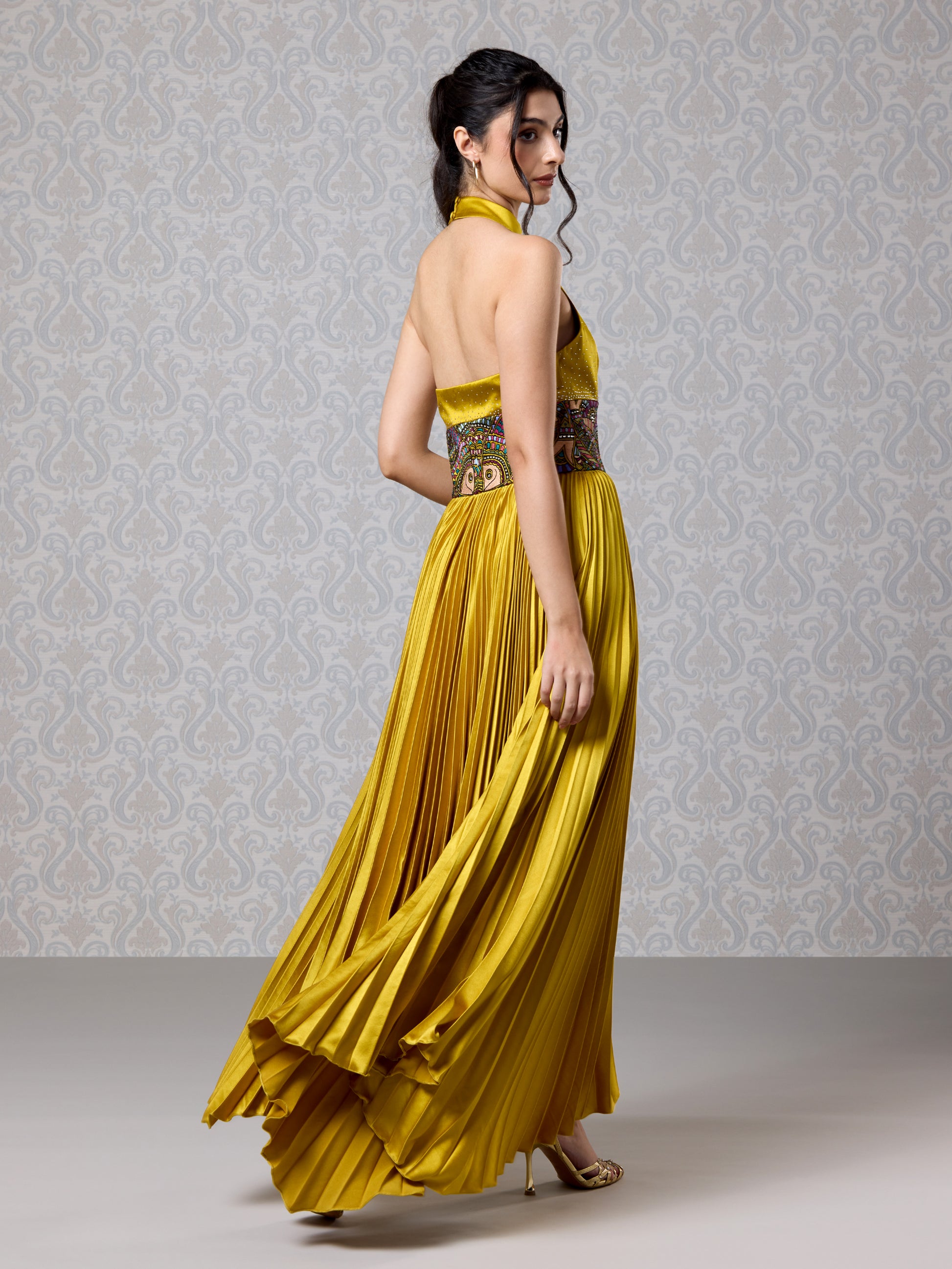 Side pose in pleated Harvest Gold satin gown featuring detailed printed waistband