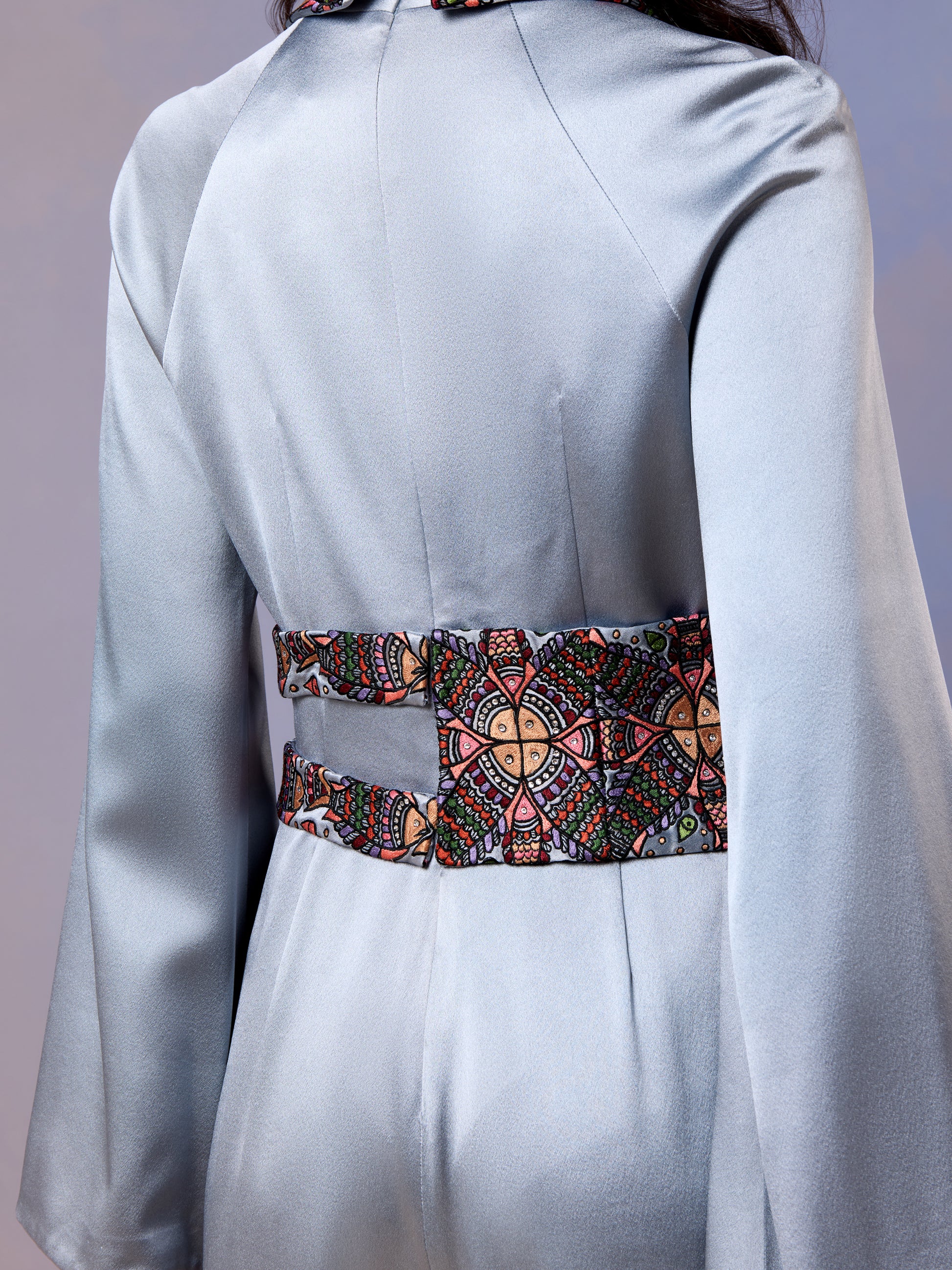 Close-up of embroidered waistband on glacier blue silk jumpsuit