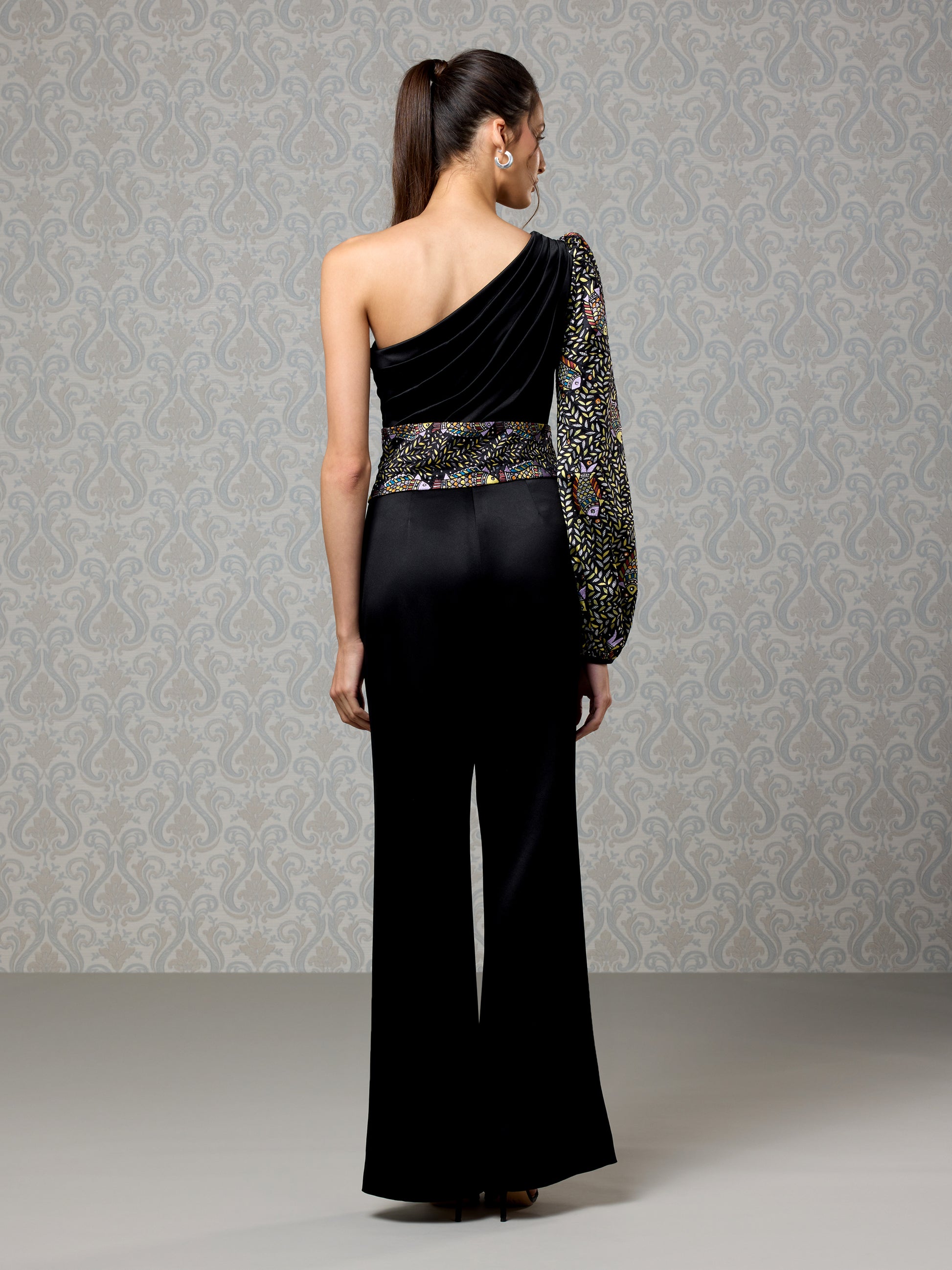 Back view of black one-shoulder satin jumpsuit with wide-leg silhouette