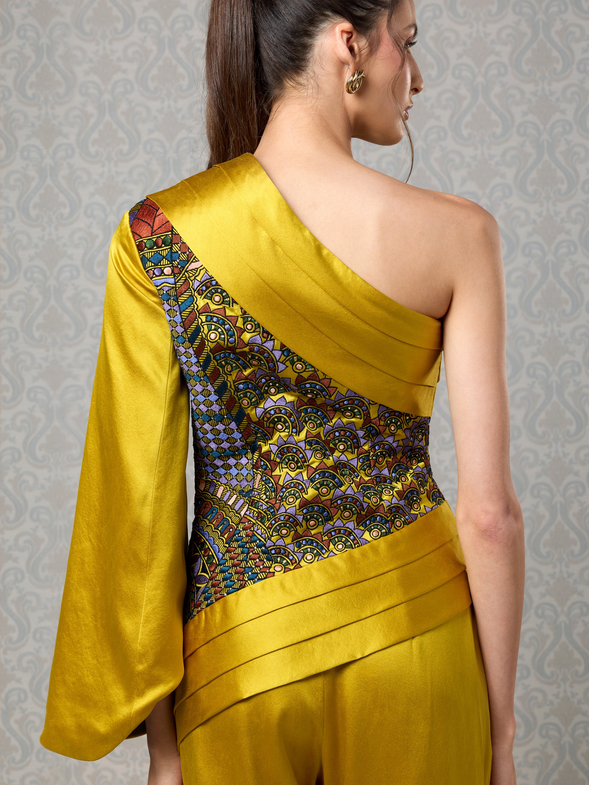 Close-up of back embroidery and drape on harvest gold silk satin jumpsuit