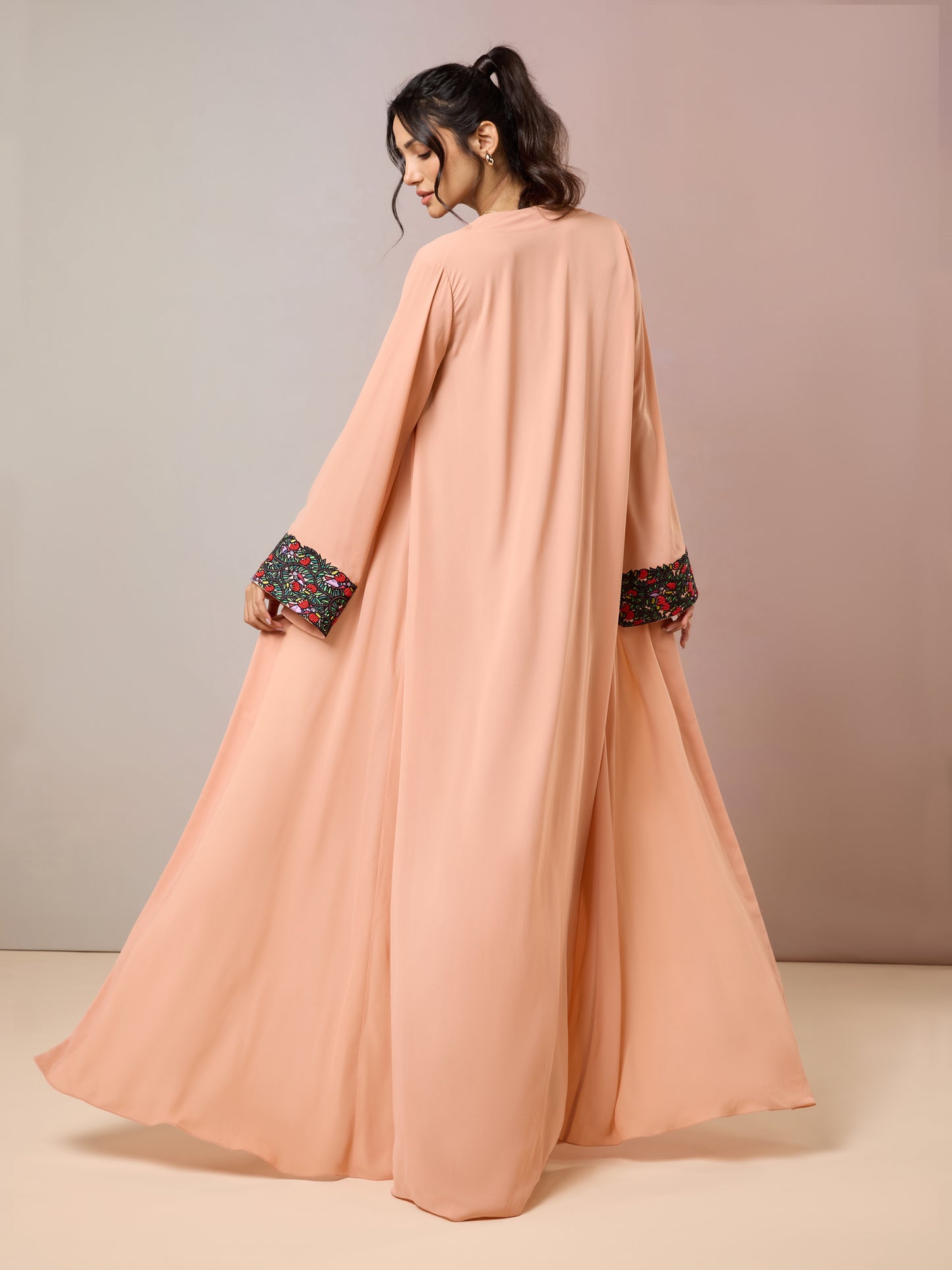 Back view of flowing peach cape over floral dress