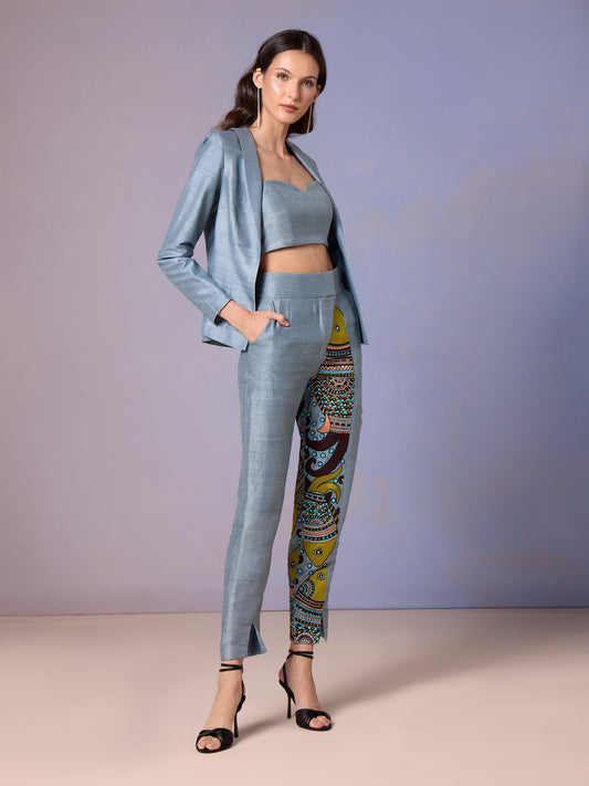 Model in Glacier Blue raw silk top, printed trousers, and matching jacket
