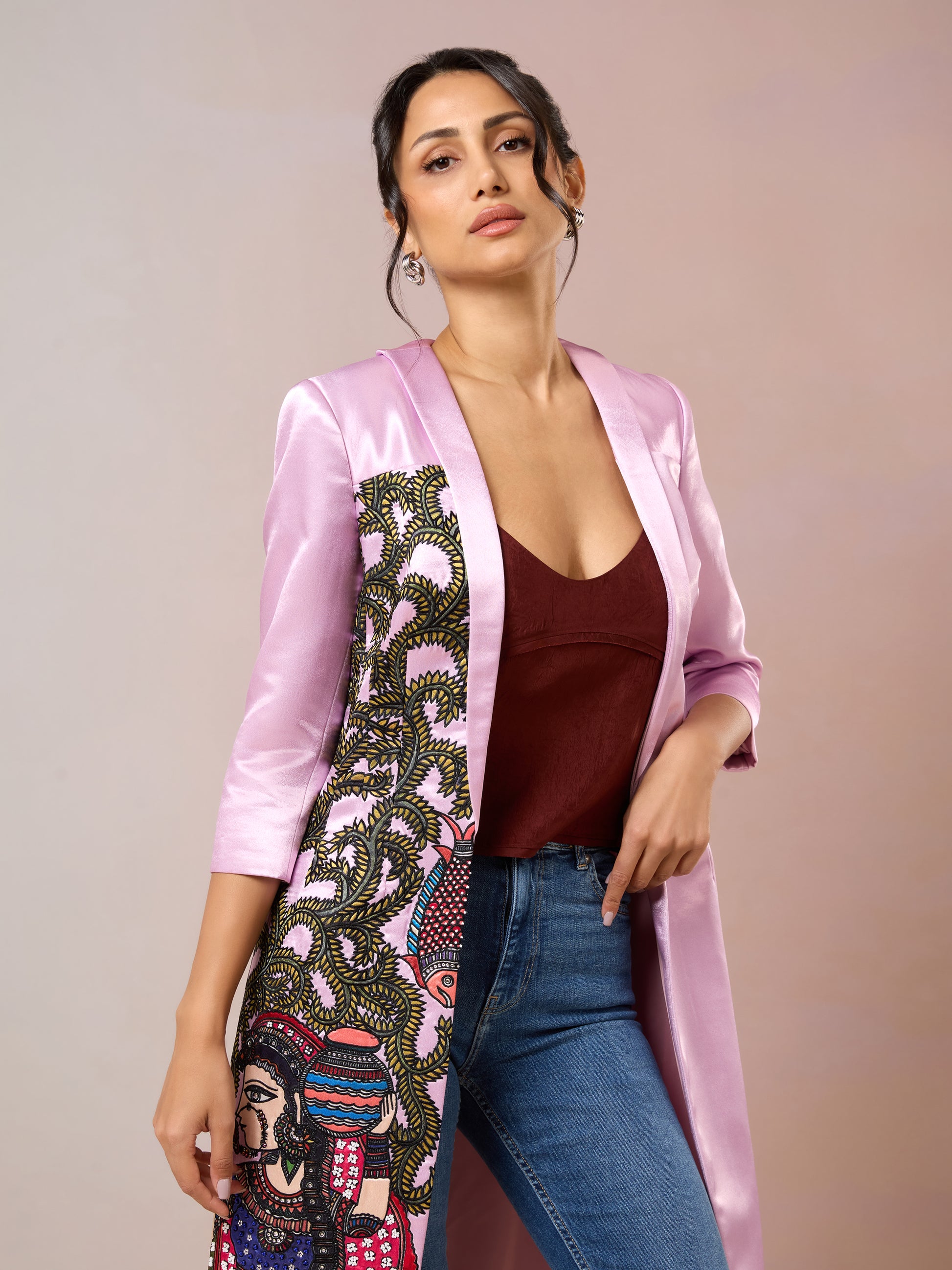 Close-up of pink embroidered jacket with ethnic art and maroon inner top