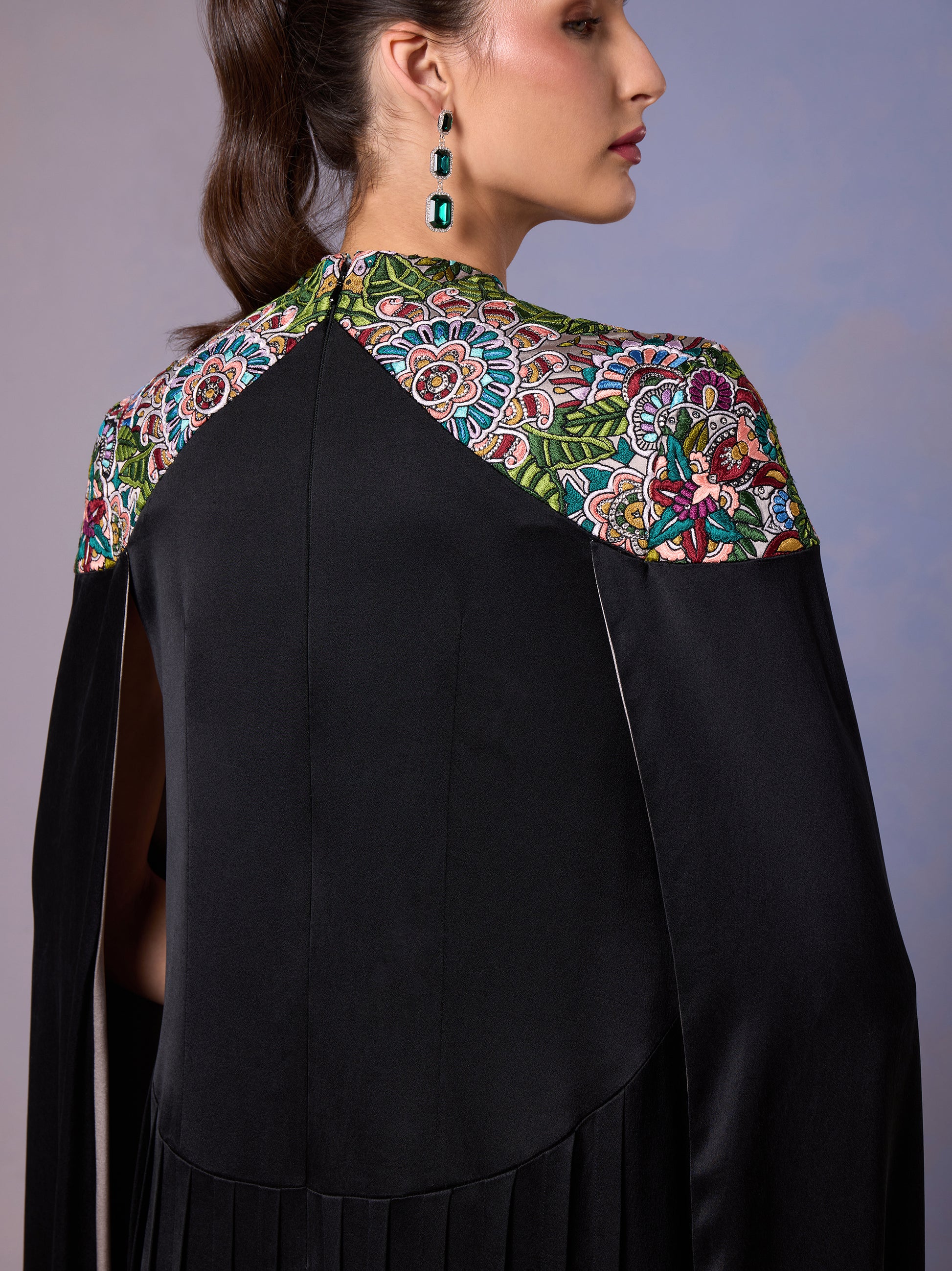 Side view of embroidered cape design on black silk kaftan