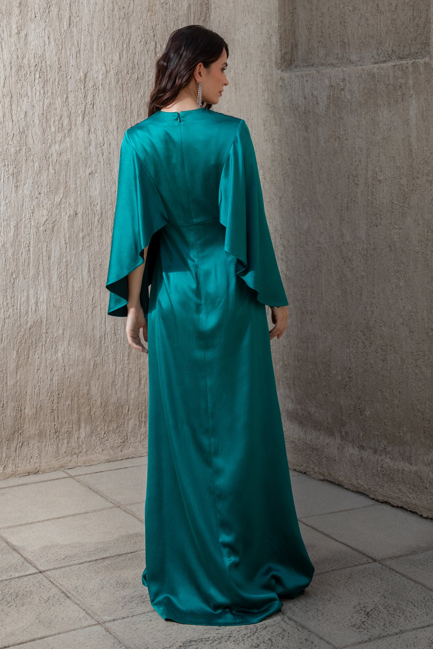 Back view of emerald evening gown with soft satin finish and flowing design