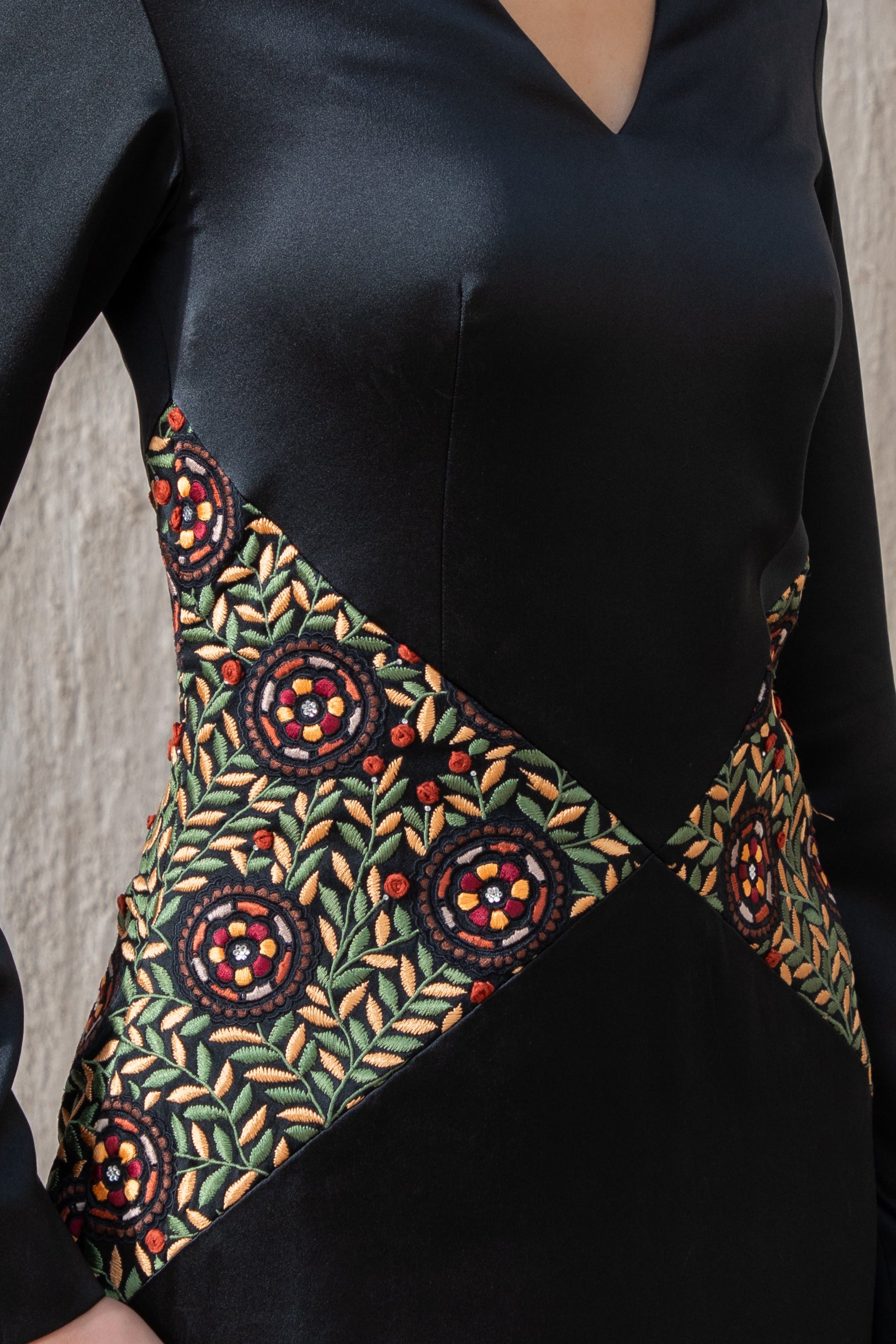Detailed embroidery on waist of black cape gown for evening wear