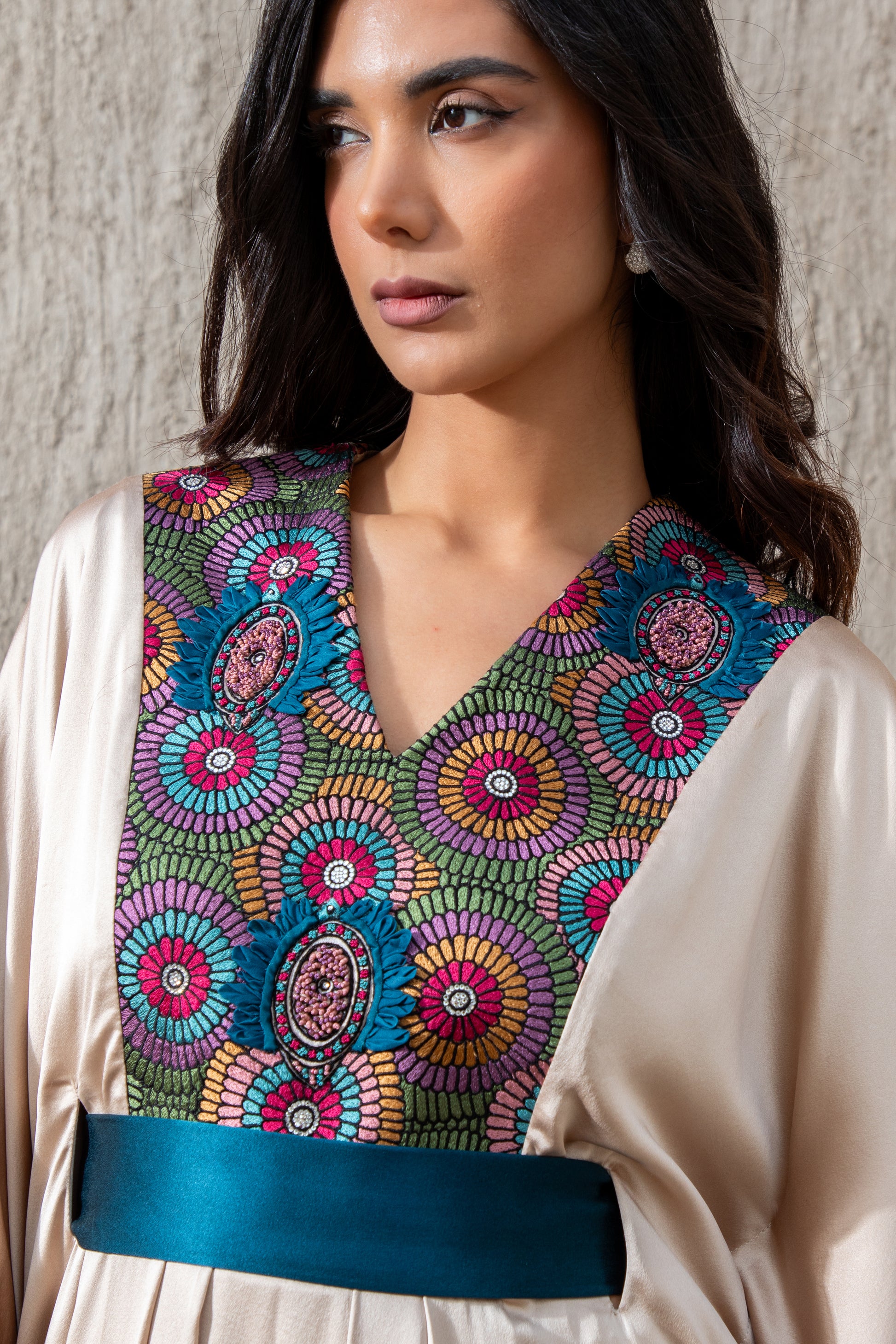 Close-up of colorful embroidered bodice on vanilla kaftan