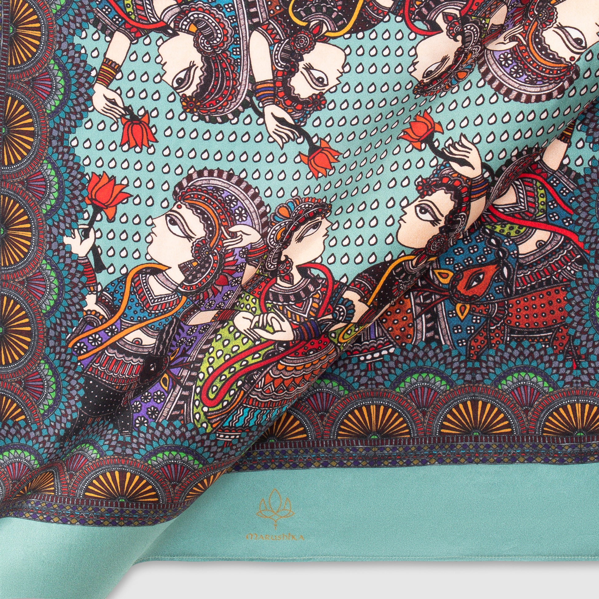Close-up view of Madhubani silk scarf showcasing intricate folk art on turquoise background
