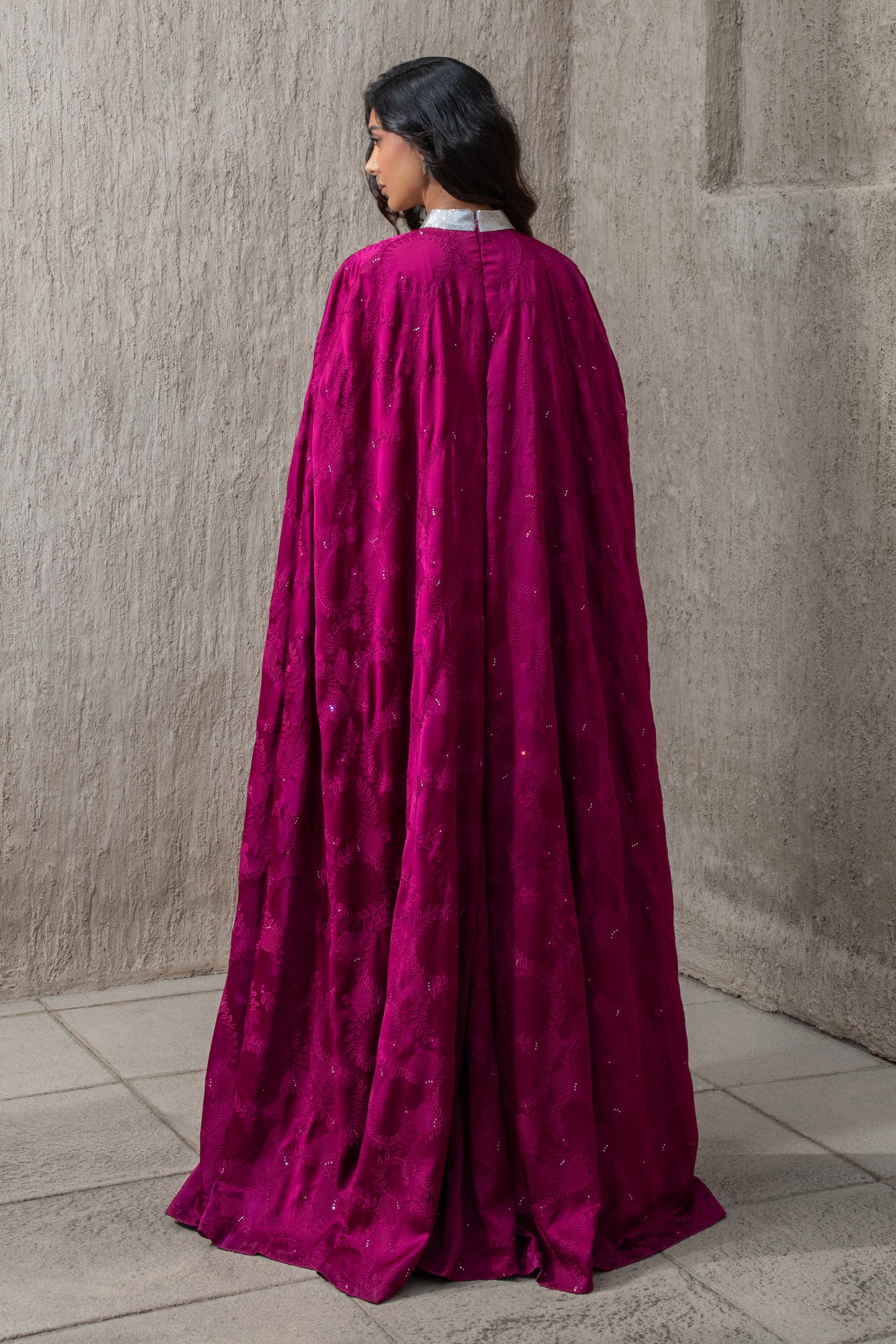Back view of flowing lace cape on cranberry evening gown