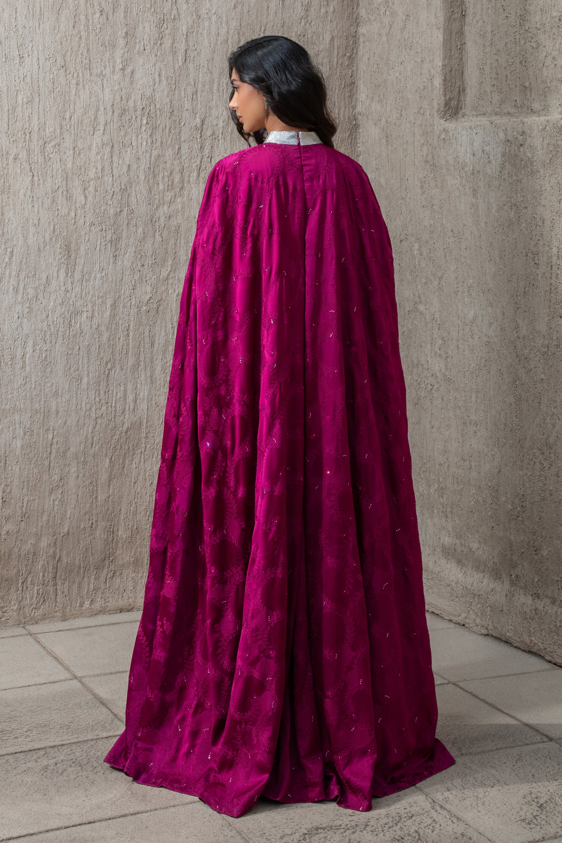 Back view of flowing lace cape on cranberry evening gown