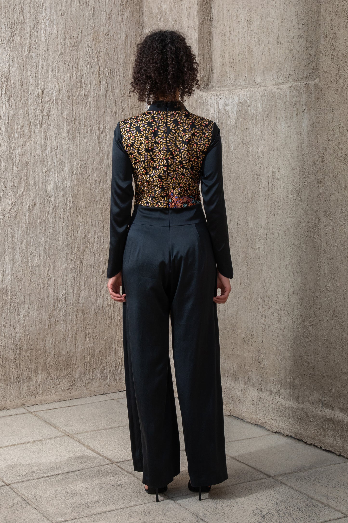 Back view of black ice jumpsuit with embroidered panel