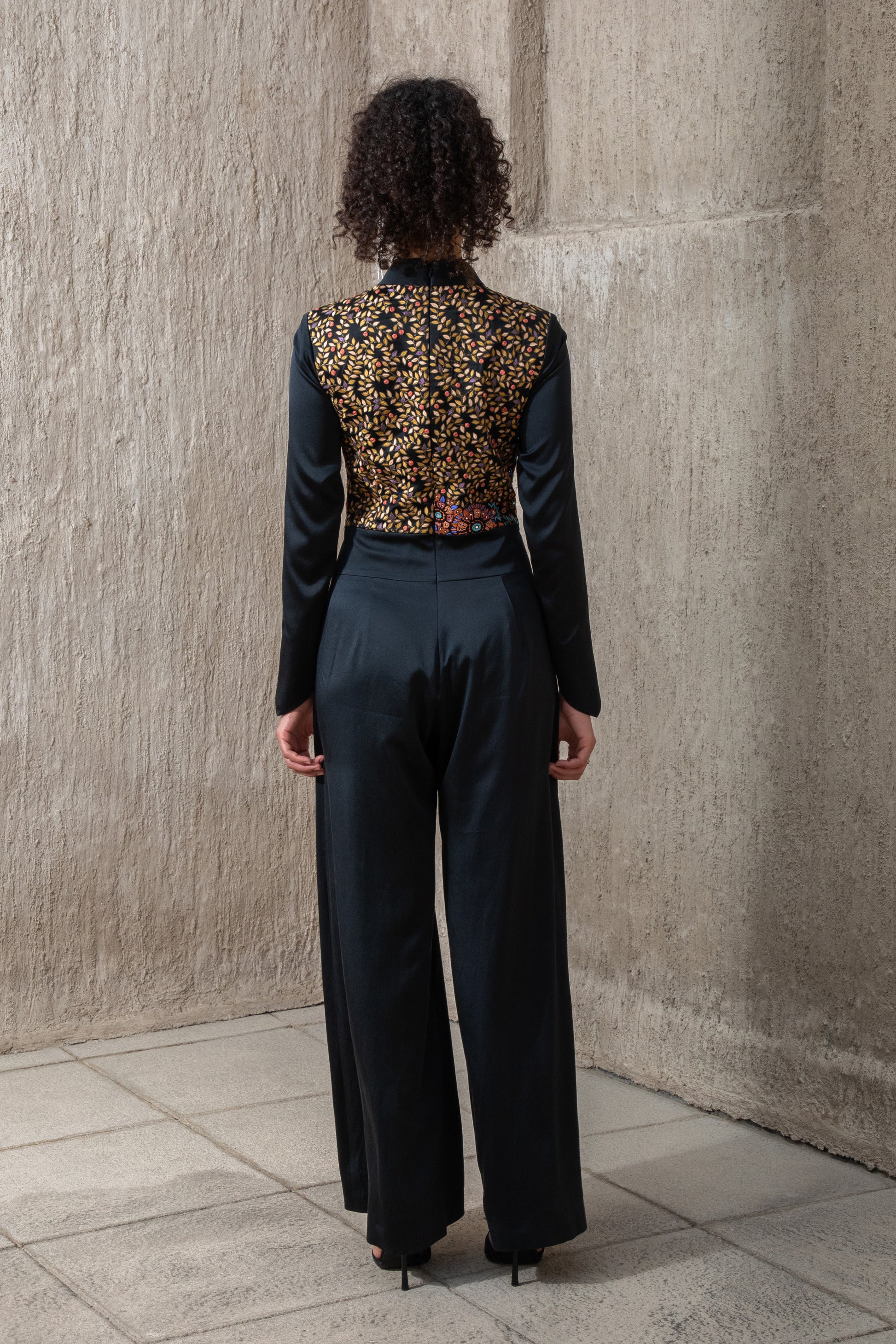 Back view of black ice jumpsuit with embroidered panel