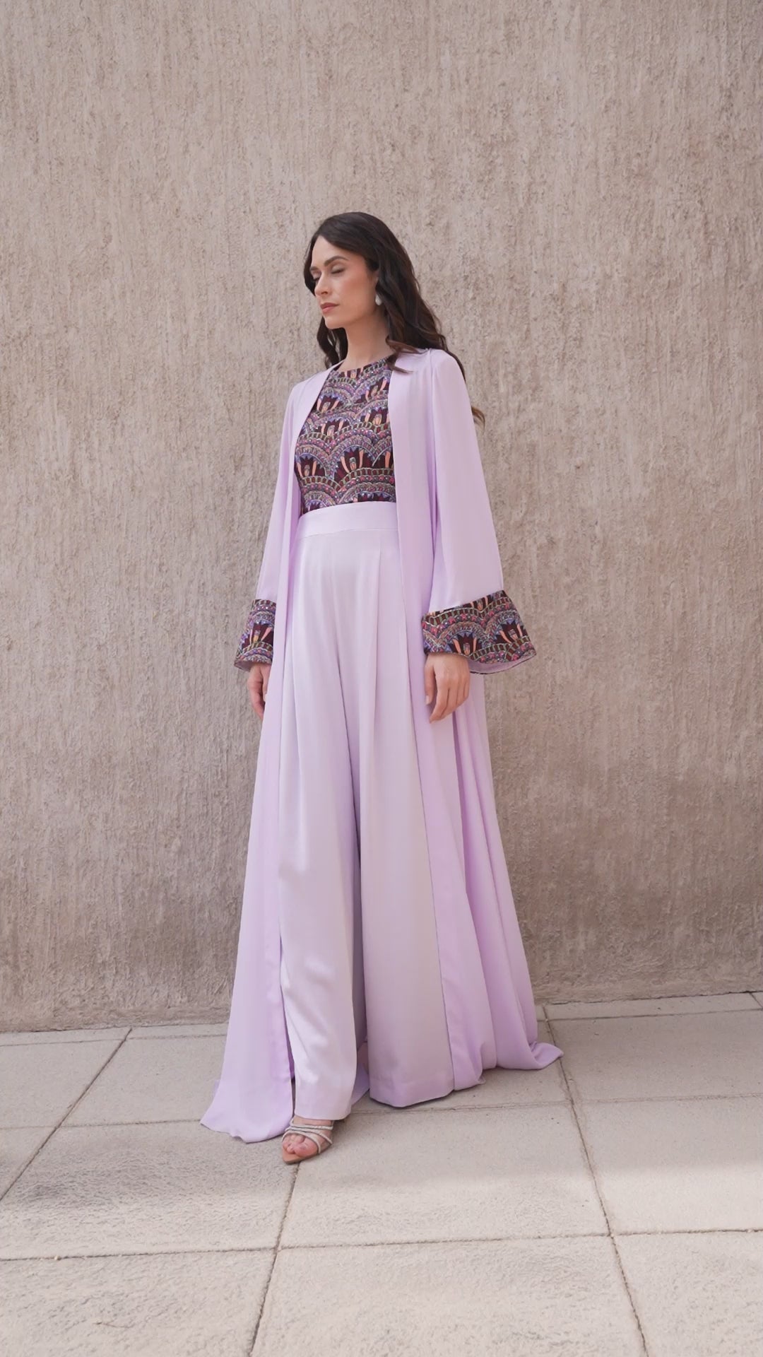 Model walking in Amethyst Haze embroidered jumpsuit with long lilac jacket