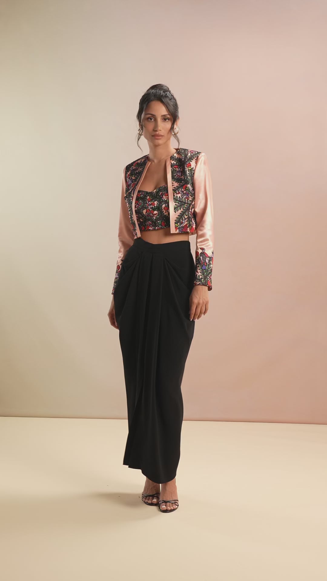 Model walking in floral embroidered bustier and satin crop jacket set