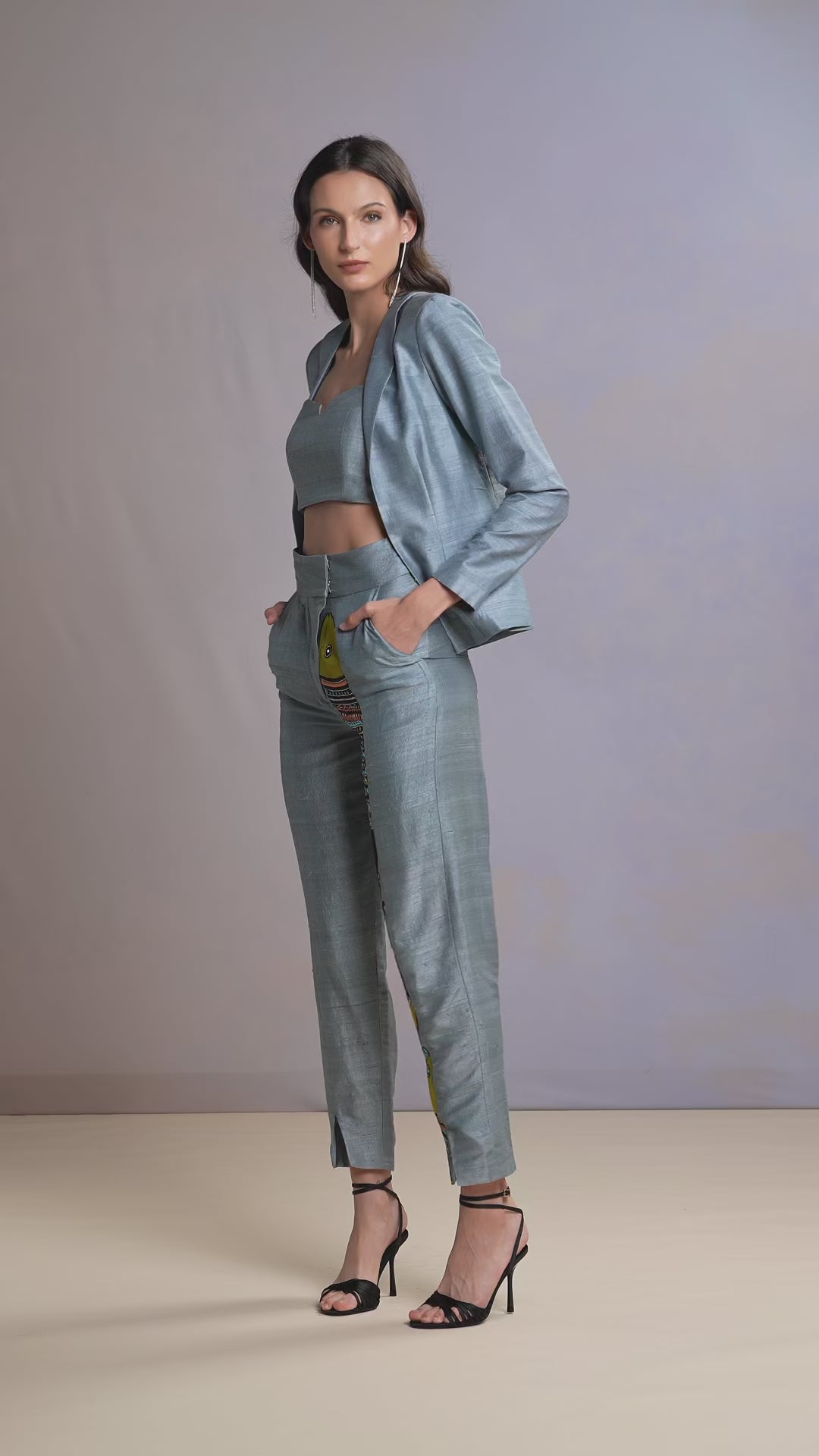 Model walking in Glacier Blue raw silk top, printed trousers, and jacket