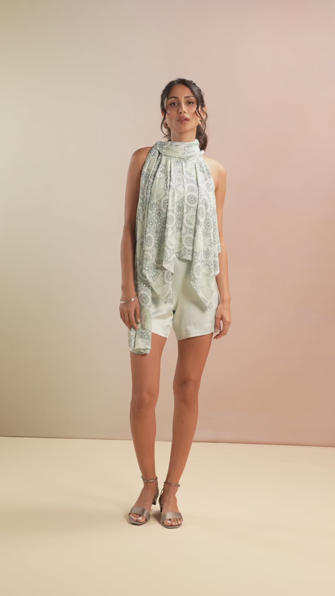 Model walking in Sea Glass printed top with white shorts