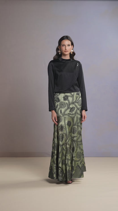 Model walking in Sage Whisper green skirt and black satin top