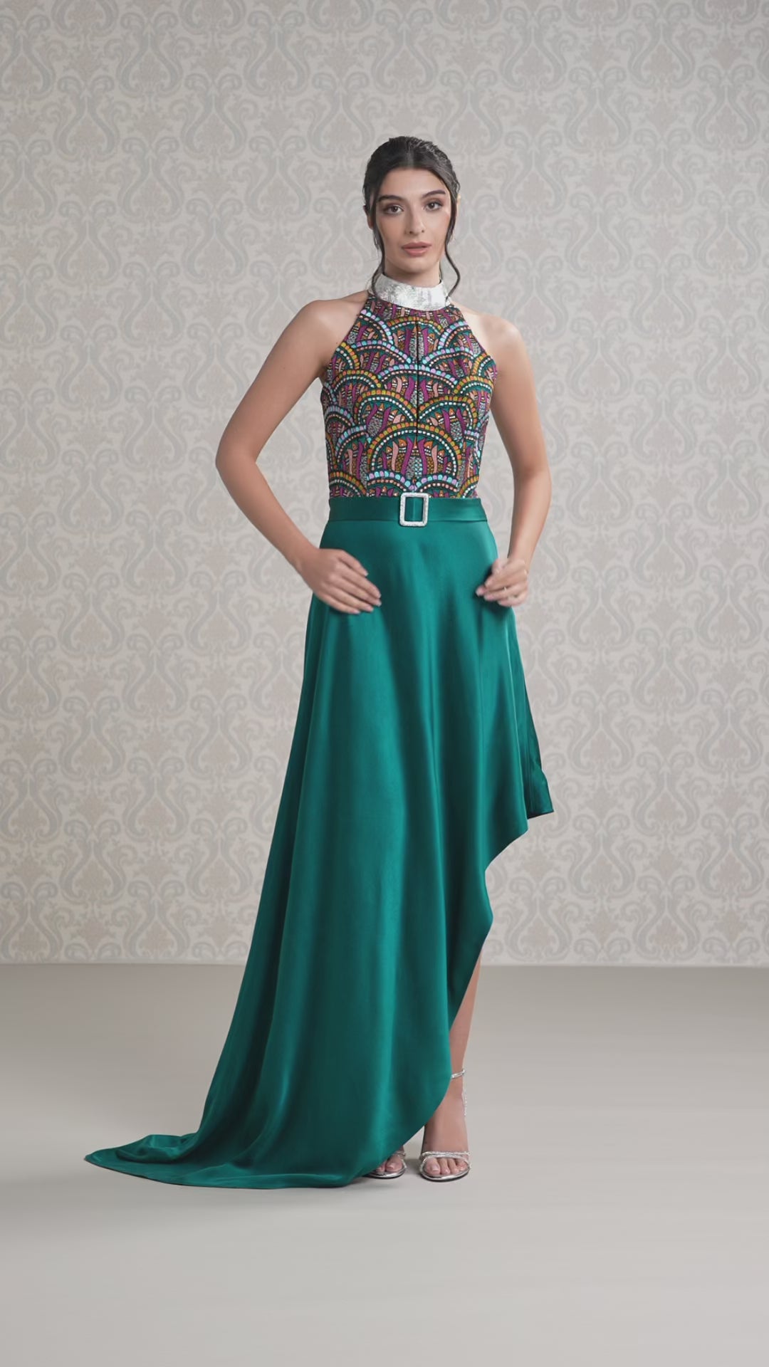 Model walking in emerald silk satin asymmetrical dress showcasing flow and detail