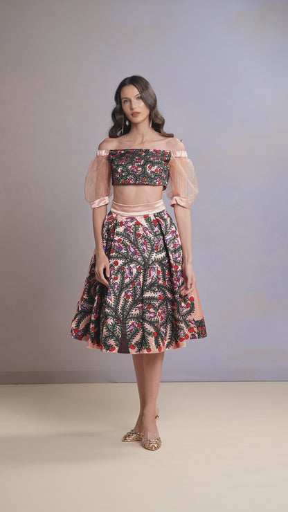 Model twirling in Coral Blush off-shoulder top and floral skirt set