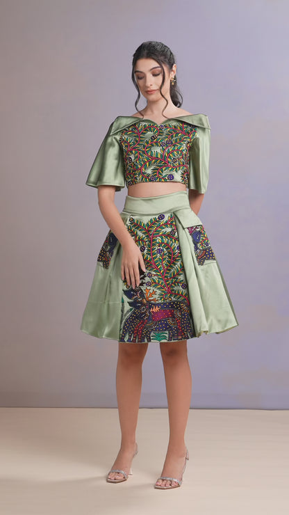 Video of women wearing sage green skirt set with embroidered top