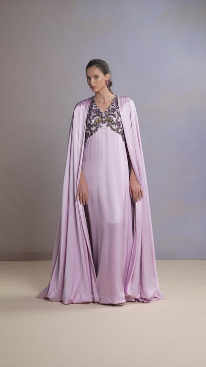 Model walking in French Lilac silk kaftan with cape and embellished neckline