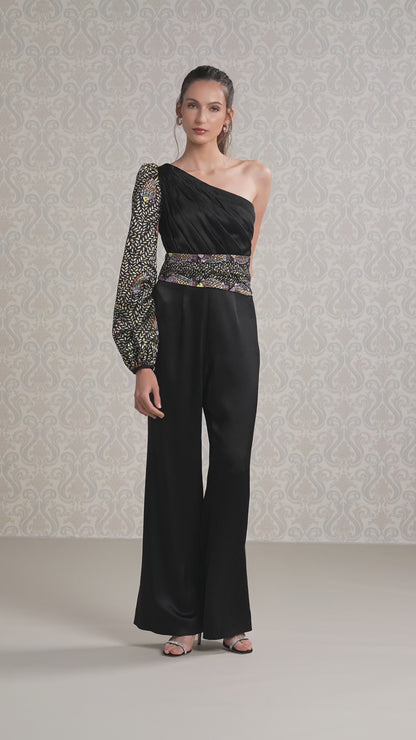 women walking in black ice silk satin one-shoulder jumpsuit with sequined details