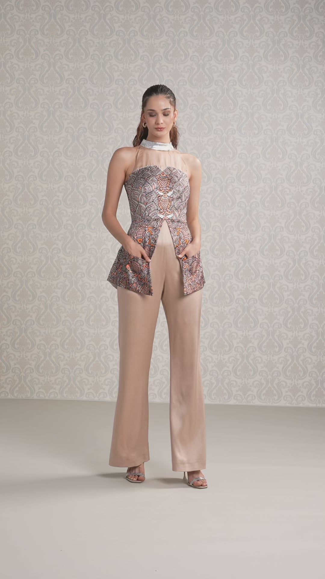 Model walking in vanilla silk satin jumpsuit with flowy printed organza overlay