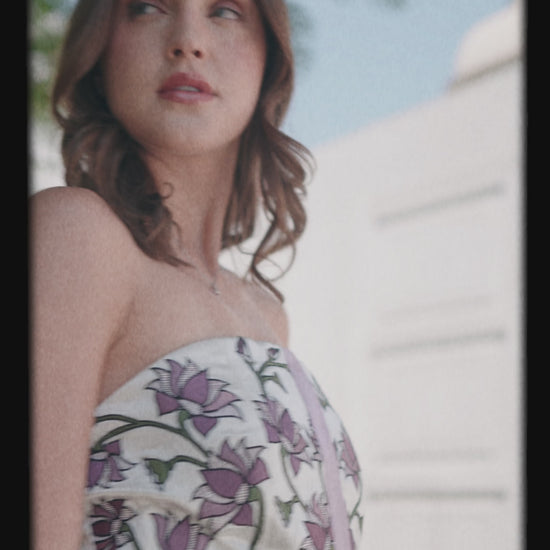 Women showcasing strapless white dress with purple floral print  luxury collection