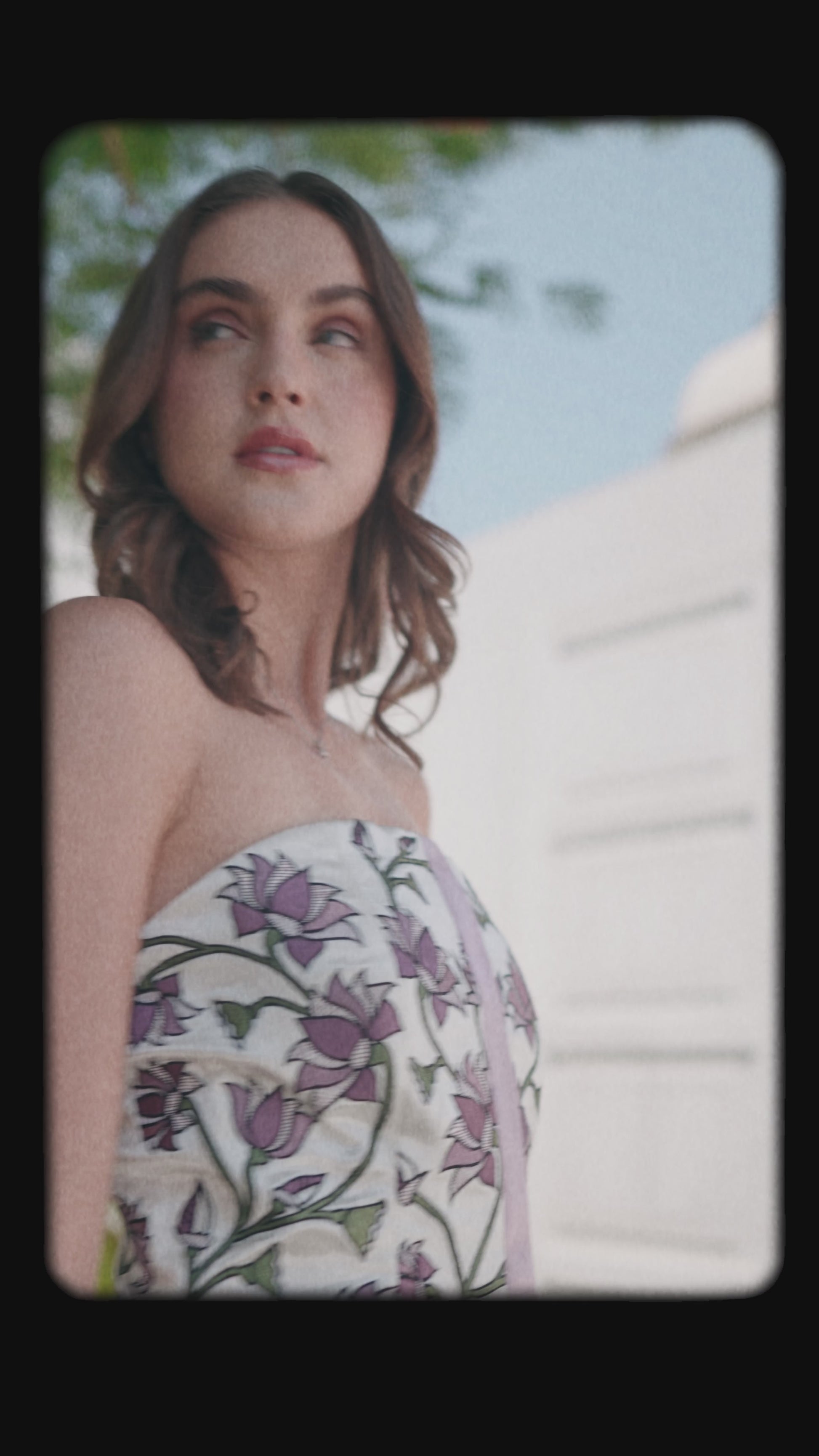Women showcasing strapless white dress with purple floral print  luxury collection